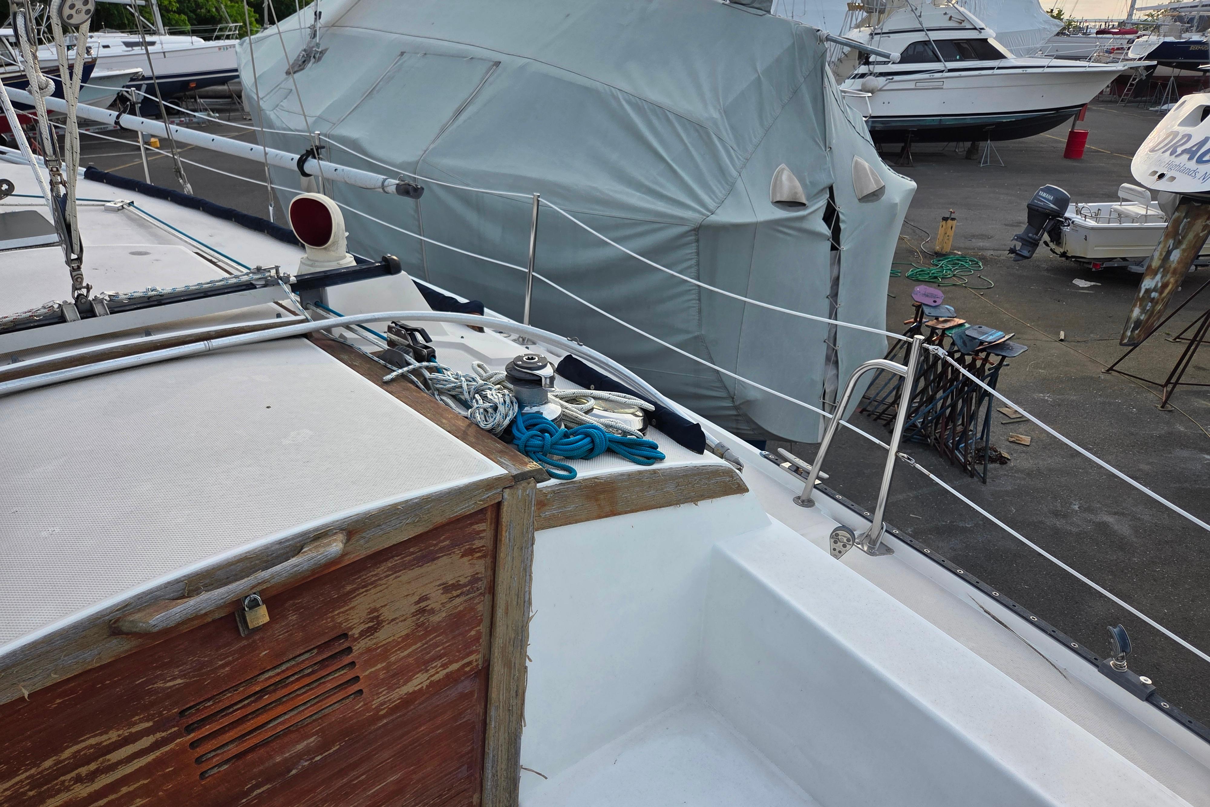 Catalina 355 sailboat deck with ropes and covered boats in marina, 1986 model.