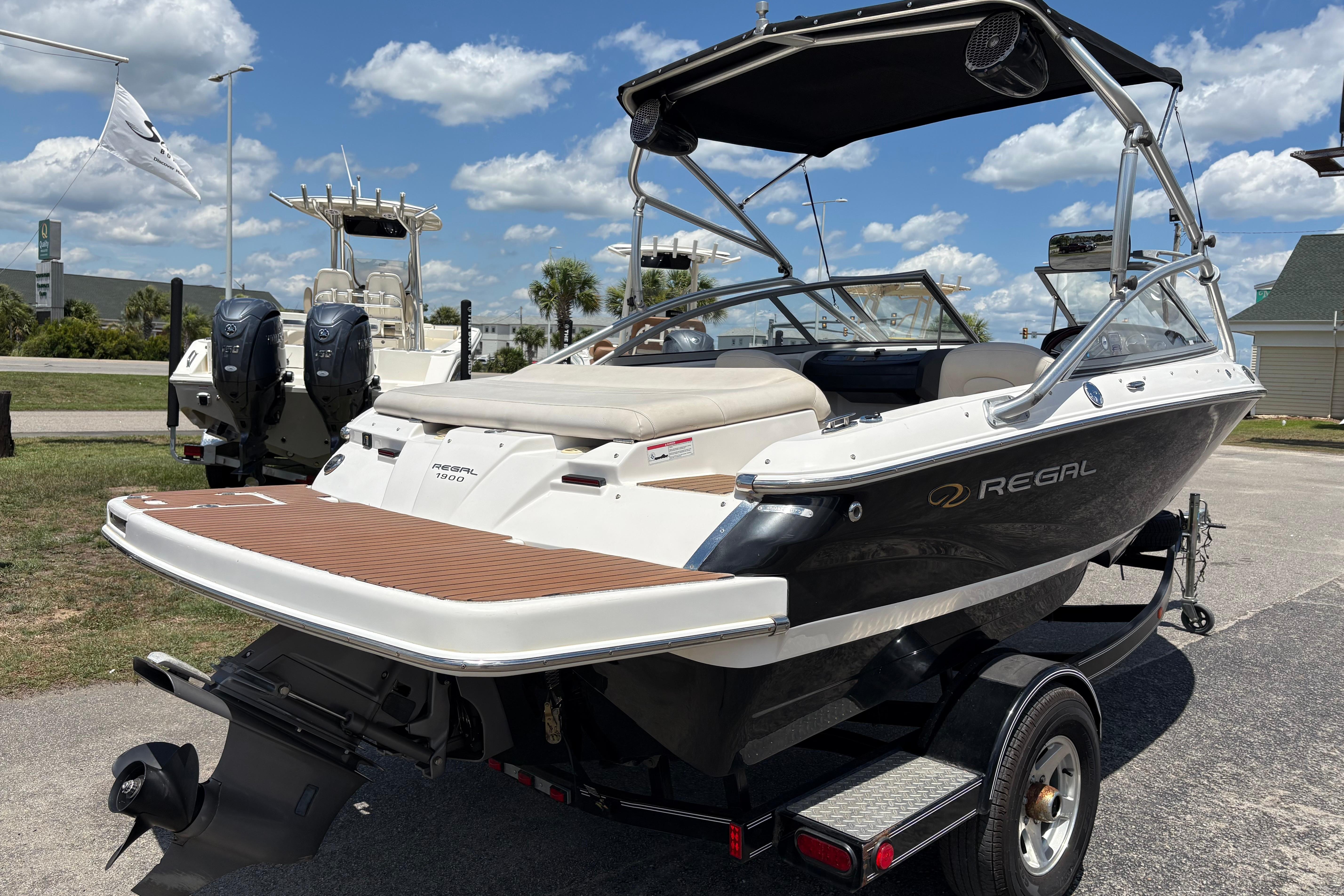 2008 Regal 1900 Bowrider boat on trailer under sunny sky.