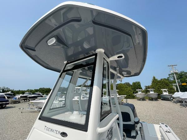 2025 Tidewater 232 CC Adventure boat with T-top, parked in a marina.