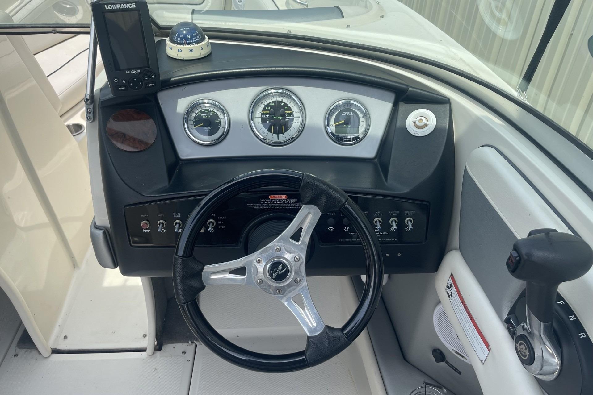 2010 Sea Ray 230 Bow Rider Select dashboard with steering wheel and navigation instruments.