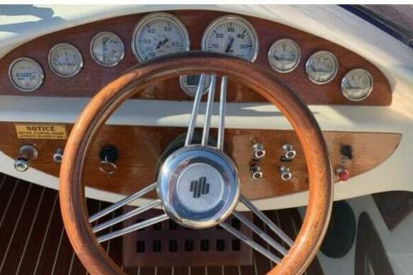 Steering wheel and dashboard of 2006 Kral Classic 700 boat with wooden accents.