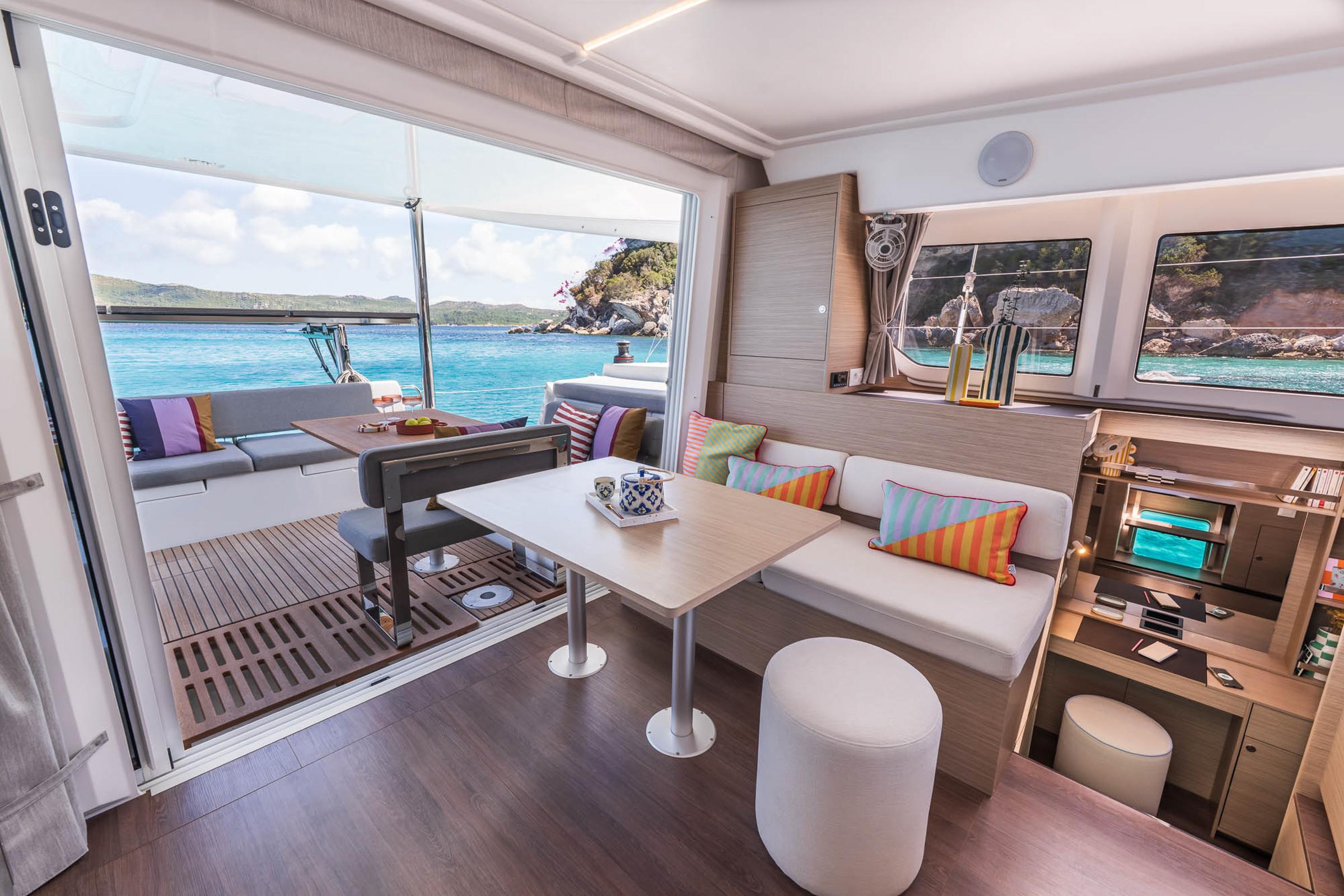 Luxurious interior of 2025 Lagoon 38 catamaran with ocean view and colorful decor.