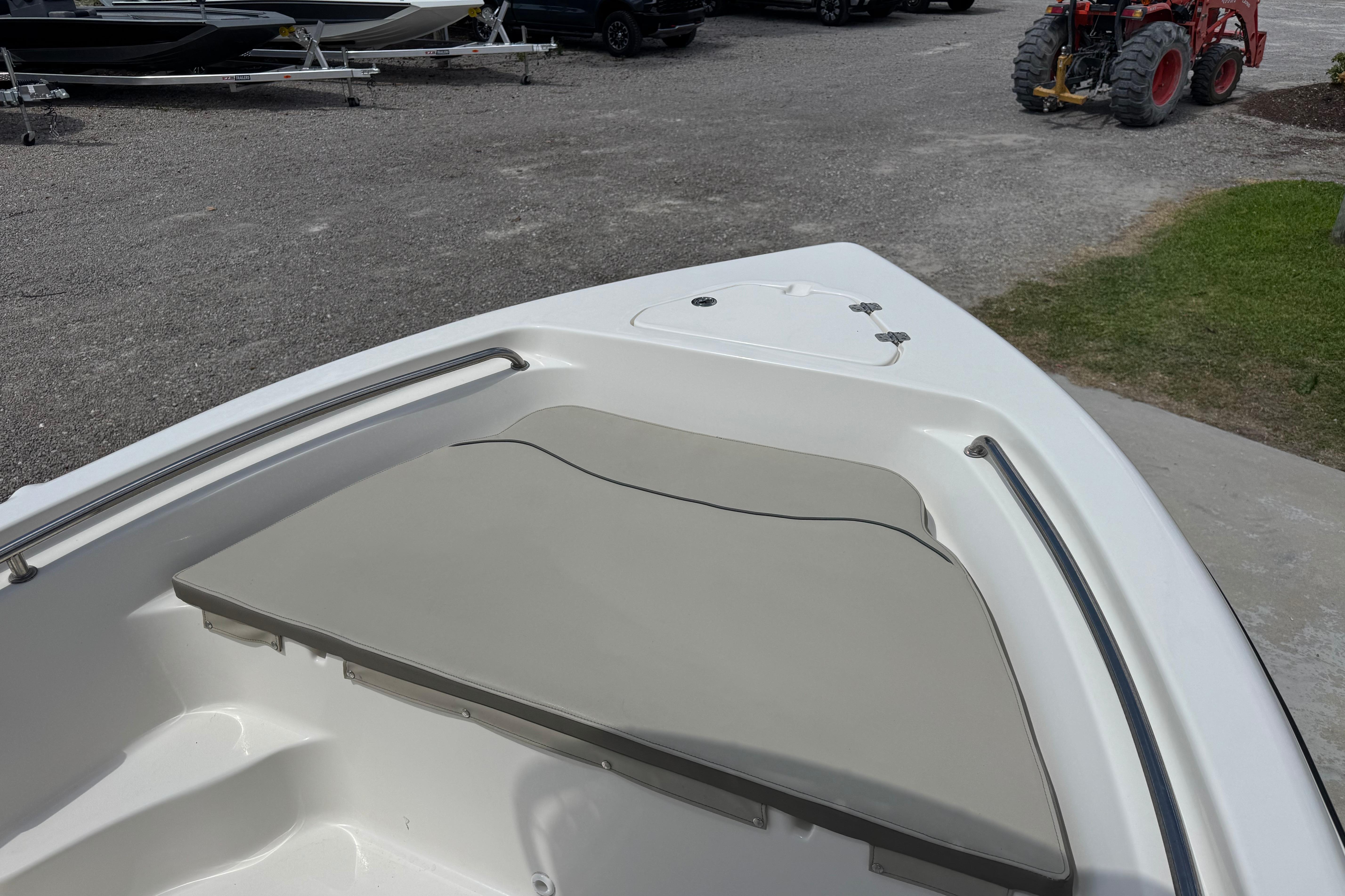 2022 Key West 189 FS boat bow with cushioned seating and storage hatch.