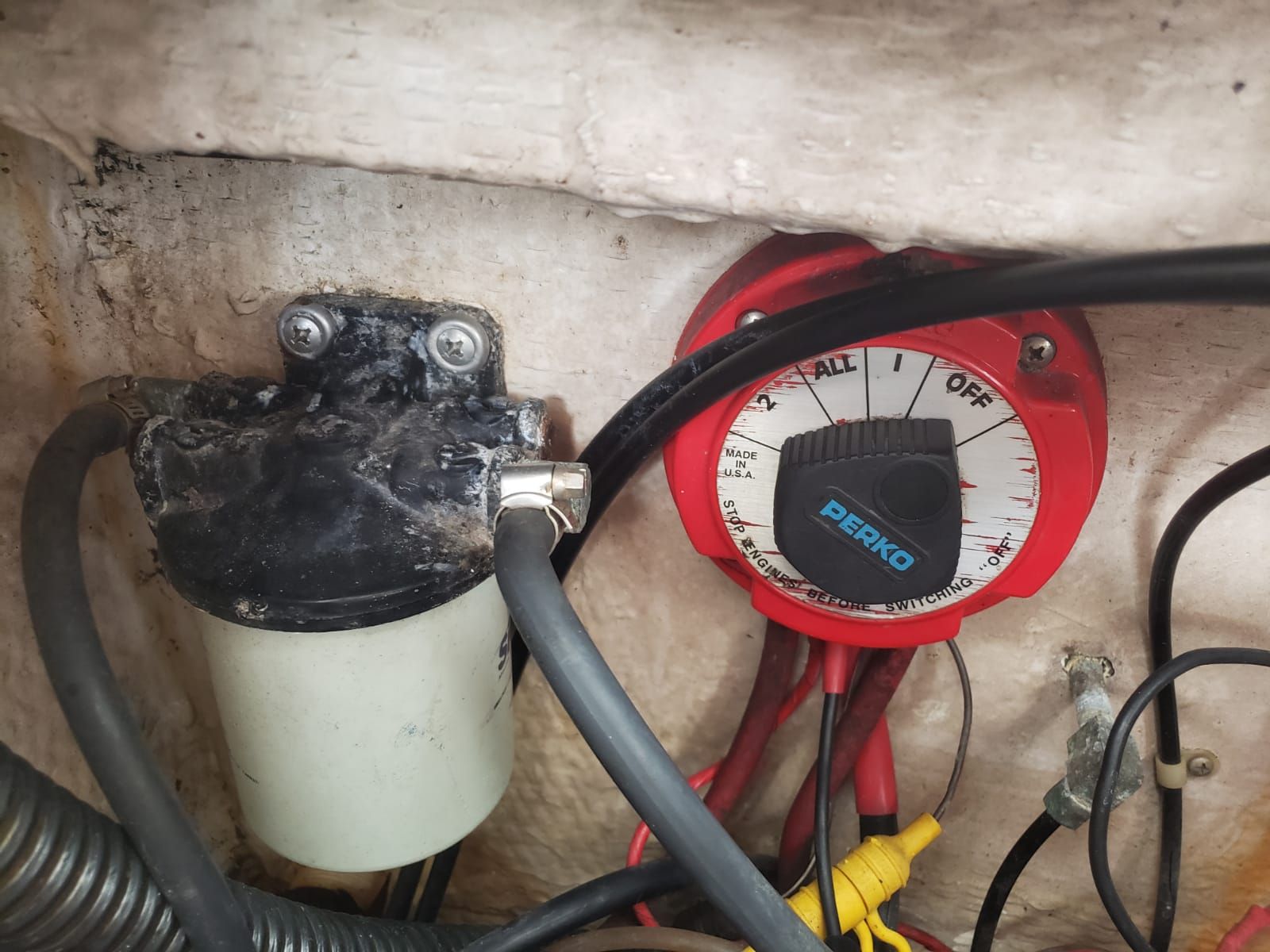 An electrical switch and cables in a boat's engine compartment, featuring a Perko switch.