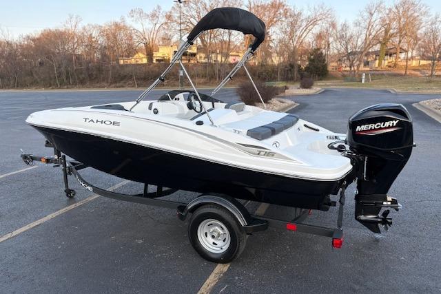 2026 Tahoe T16 boat with Mercury engine on trailer in parking lot.