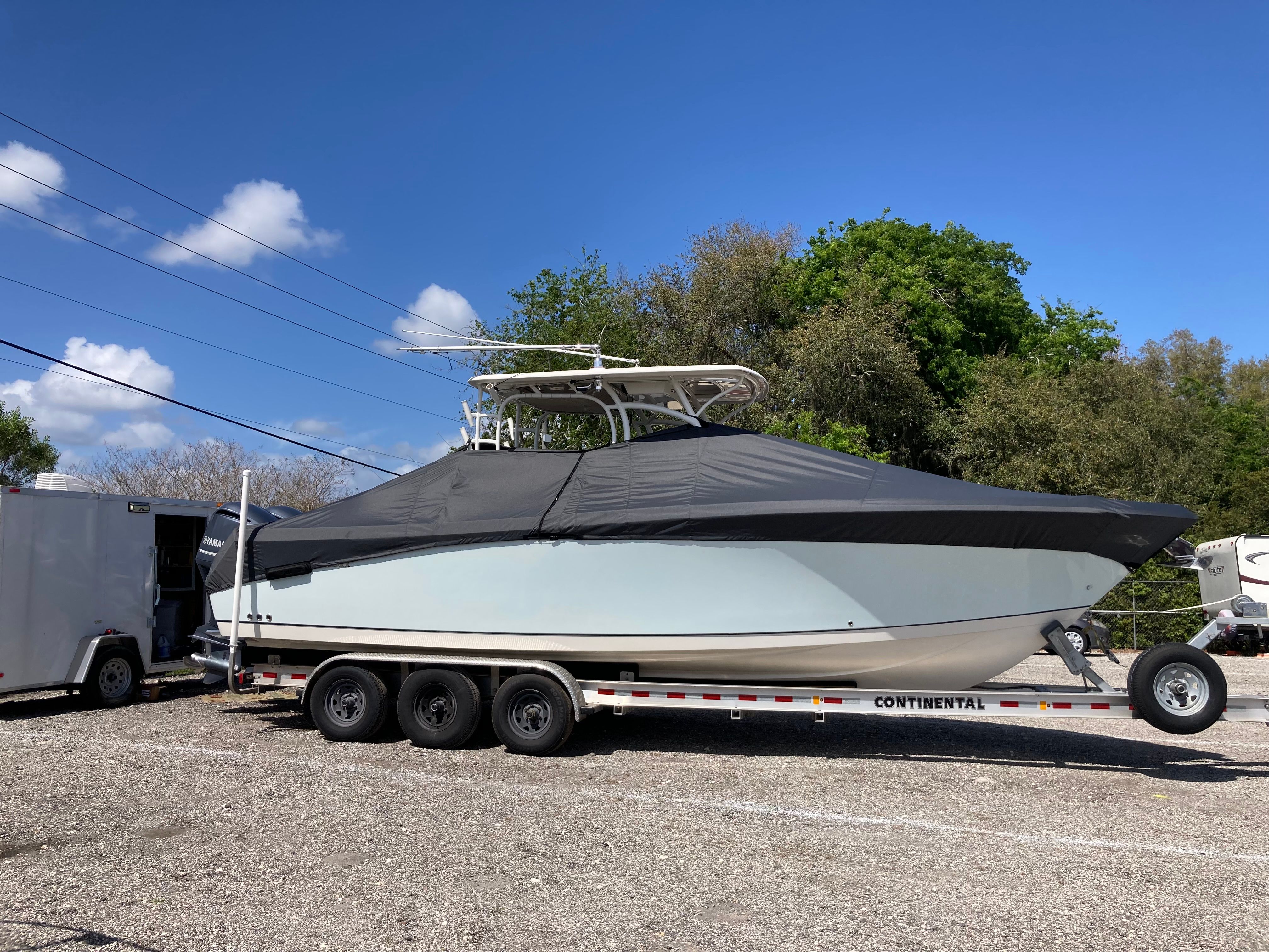 2015 Sailfish 290 CC boat parked on trailer outdoors.