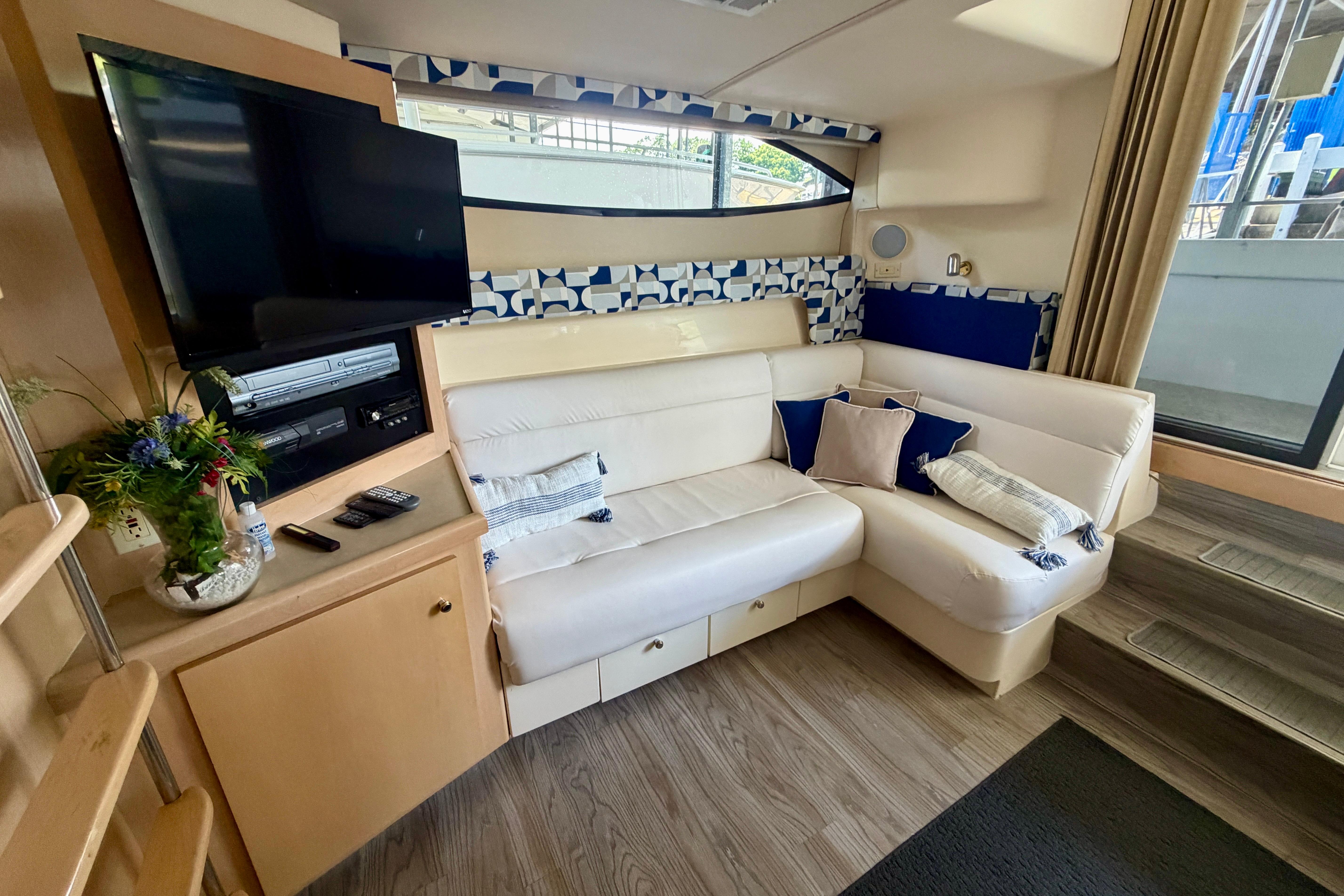 Interior of 2000 Carver 350 Mariner yacht with cozy seating and entertainment area.