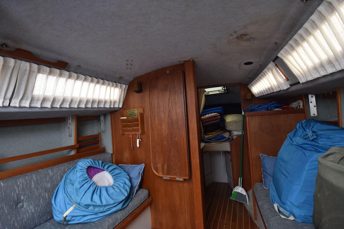 Interior of a sailboat with wooden doors and blue cushions.