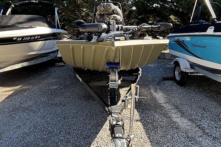2022 Lowe Roughneck 1660 boat on trailer, parked between two other boats.