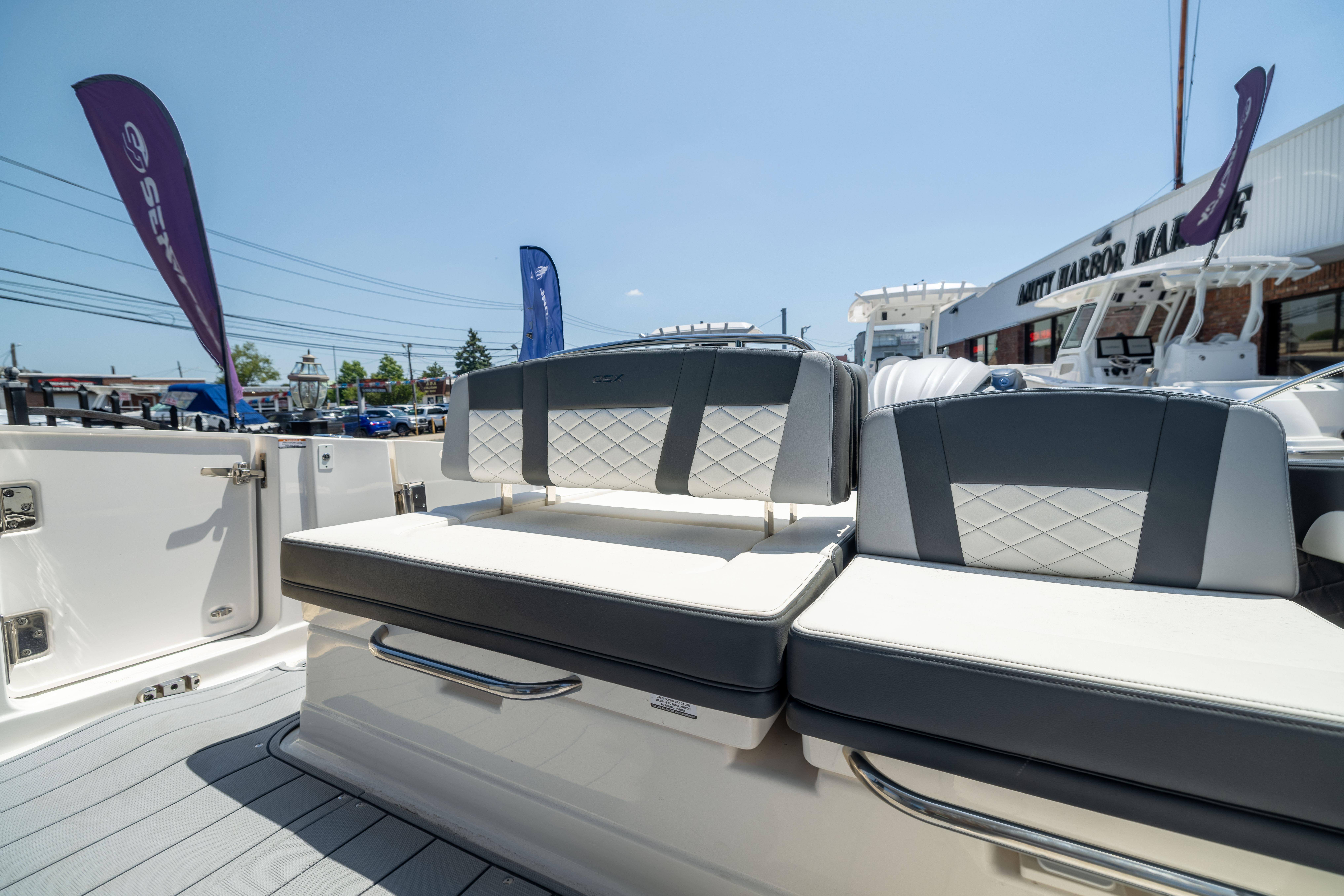 2026 Chaparral 310 OSX boat interior with cushioned seating at a marina.