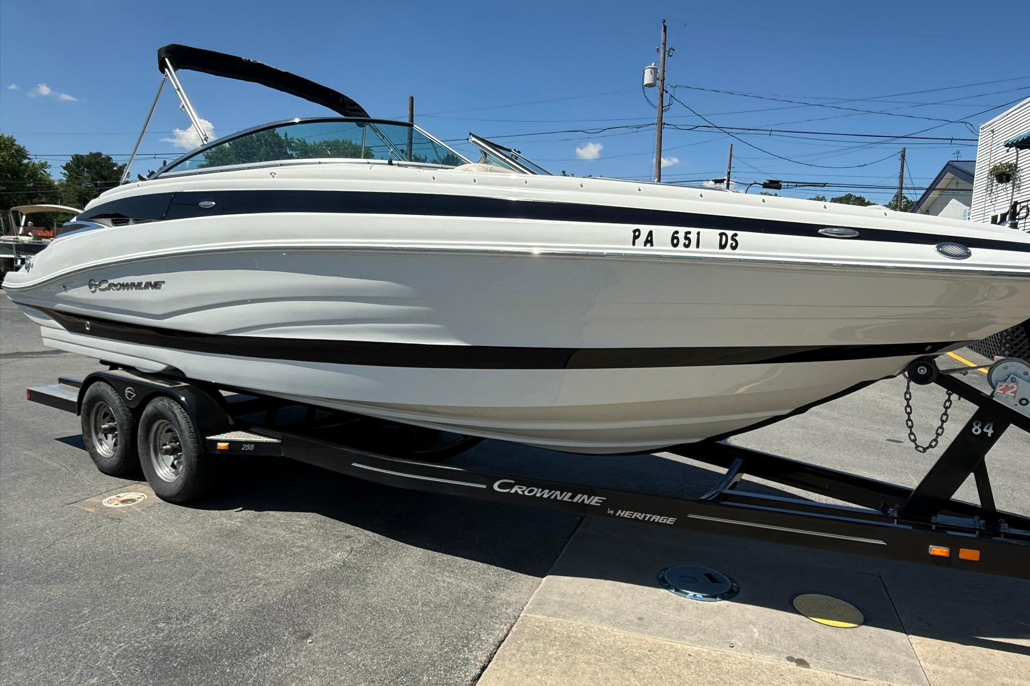 2016 Crownline 255 SS boat on trailer, parked outdoors under clear blue sky.