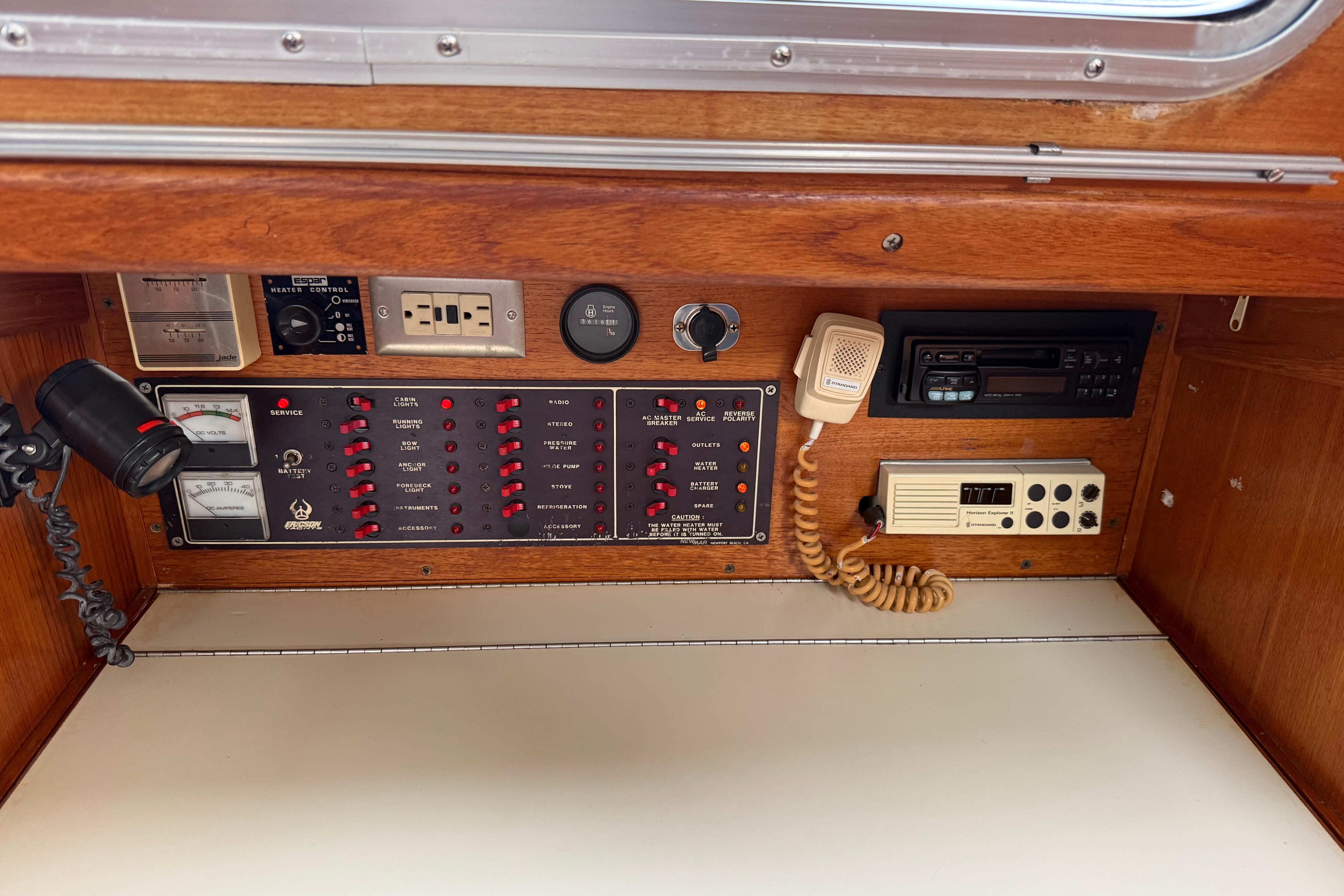 Control panel of a 1988 Ericson 32-200 sailboat with gauges and communication devices.