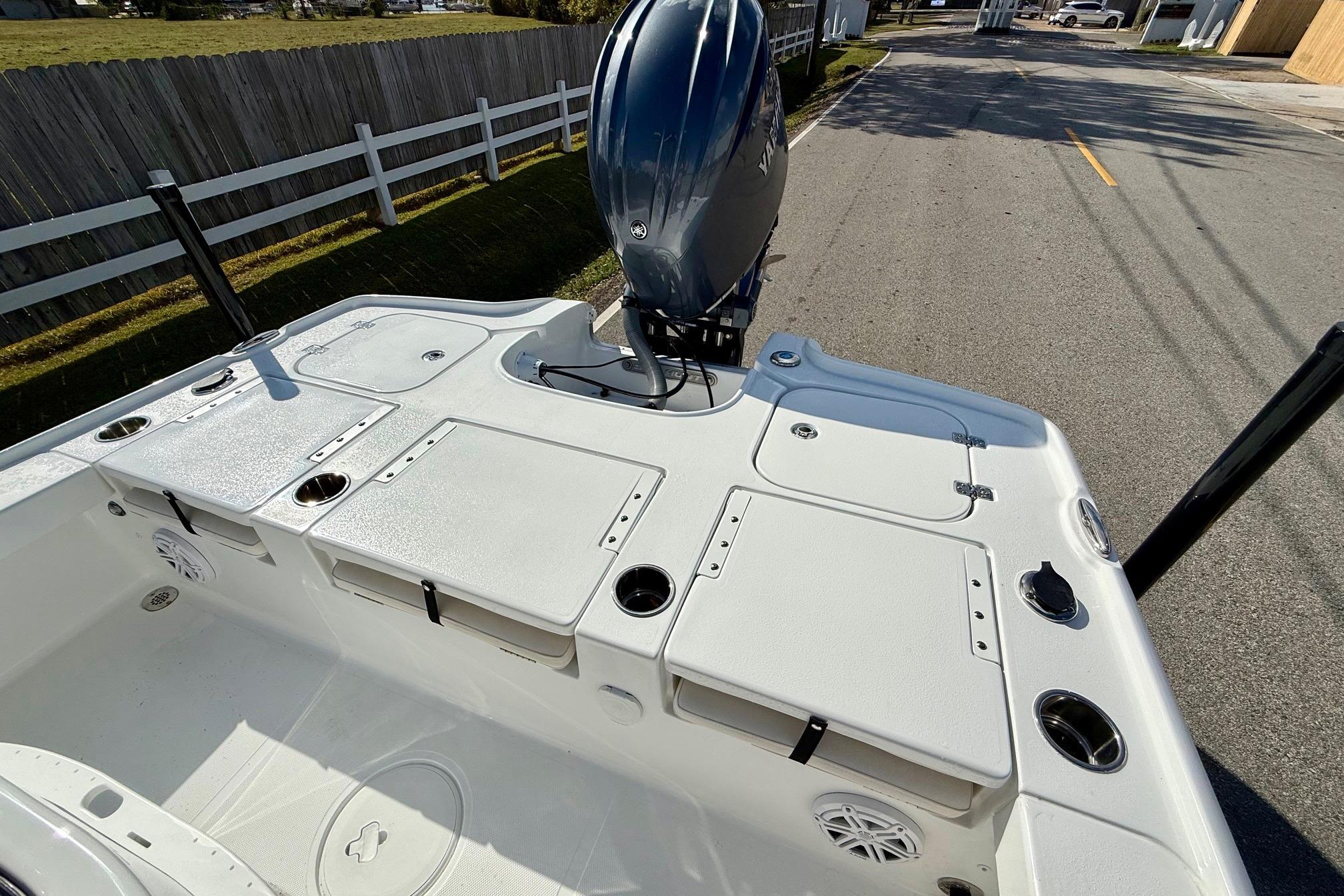 2026 Sea Hunt BX 22 BR boat deck with storage compartments and motor, parked on street.