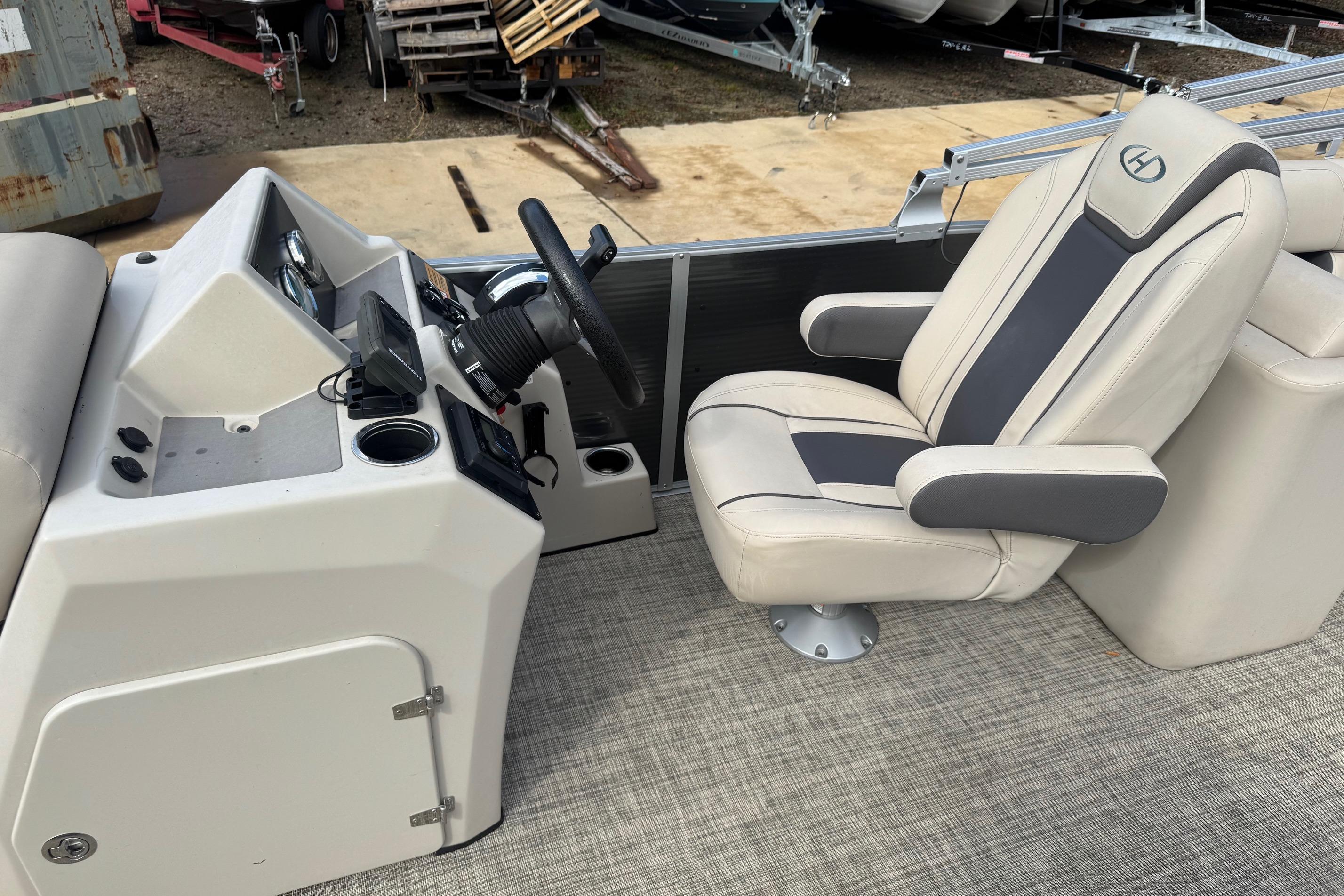 2023 Harris Cruiser 230 boat interior with steering console and captain's chair.