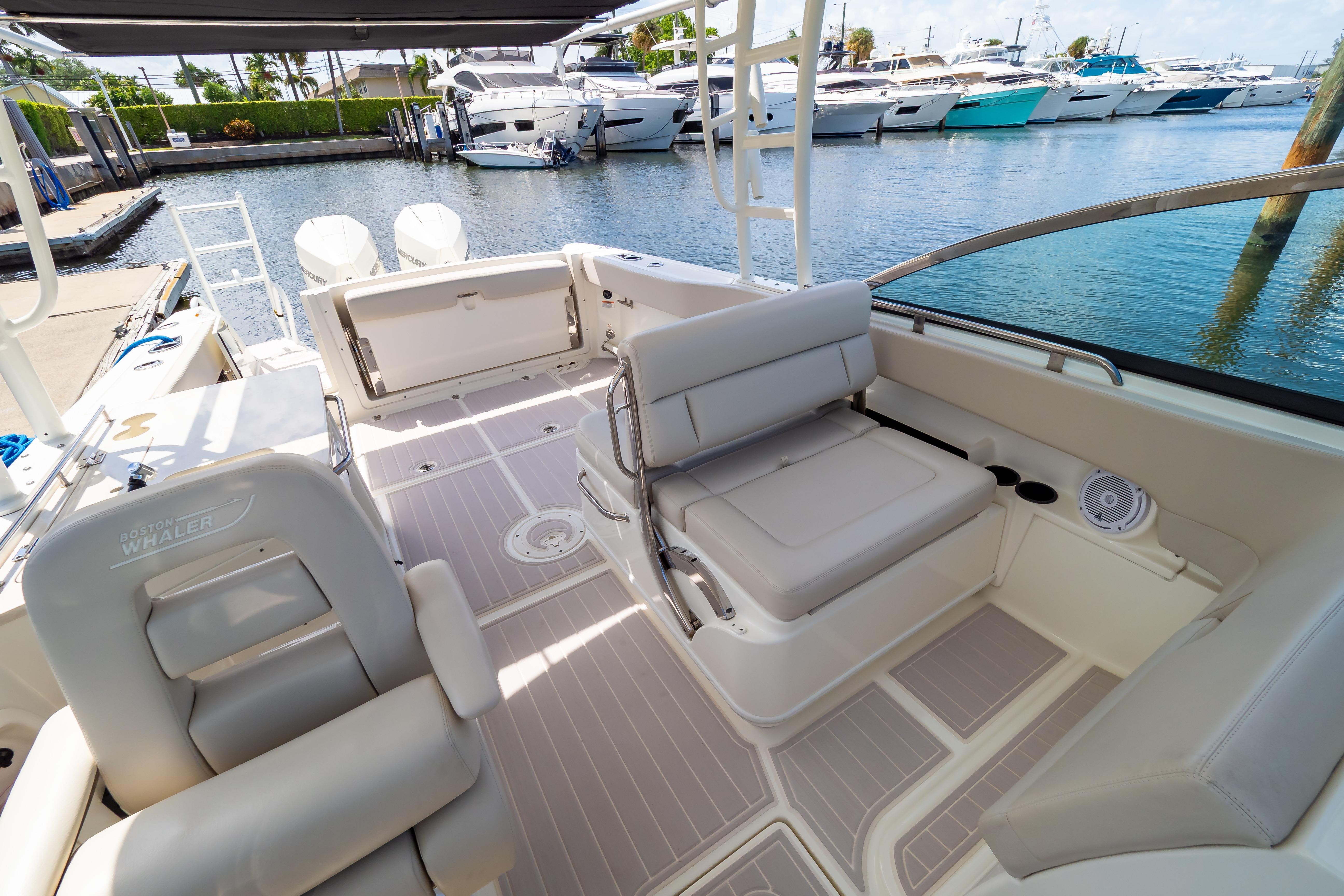 2019 Boston Whaler 270 Vantage boat interior with seating, docked near other yachts.