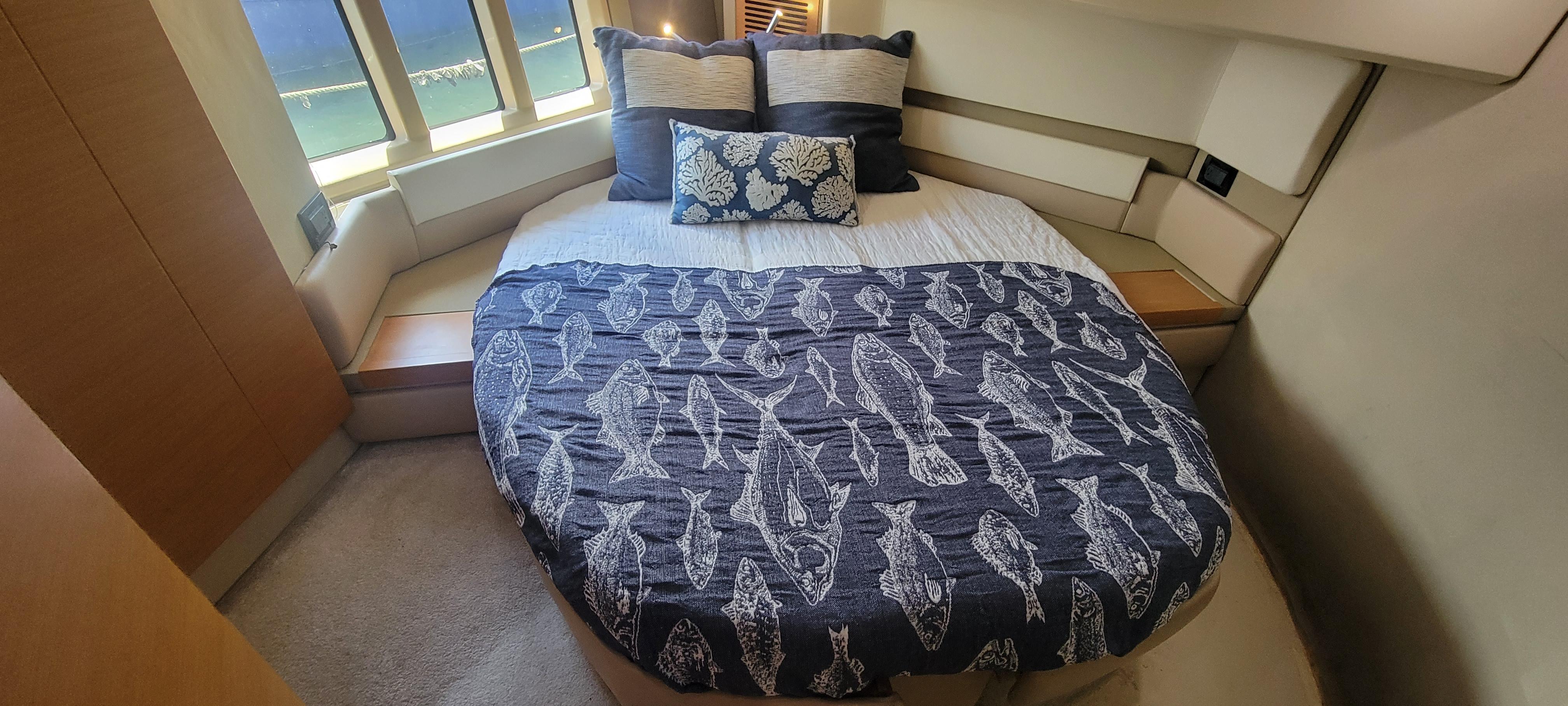 Luxurious bedroom in 2013 Azimut 45 Flybridge yacht with nautical-themed bedding.