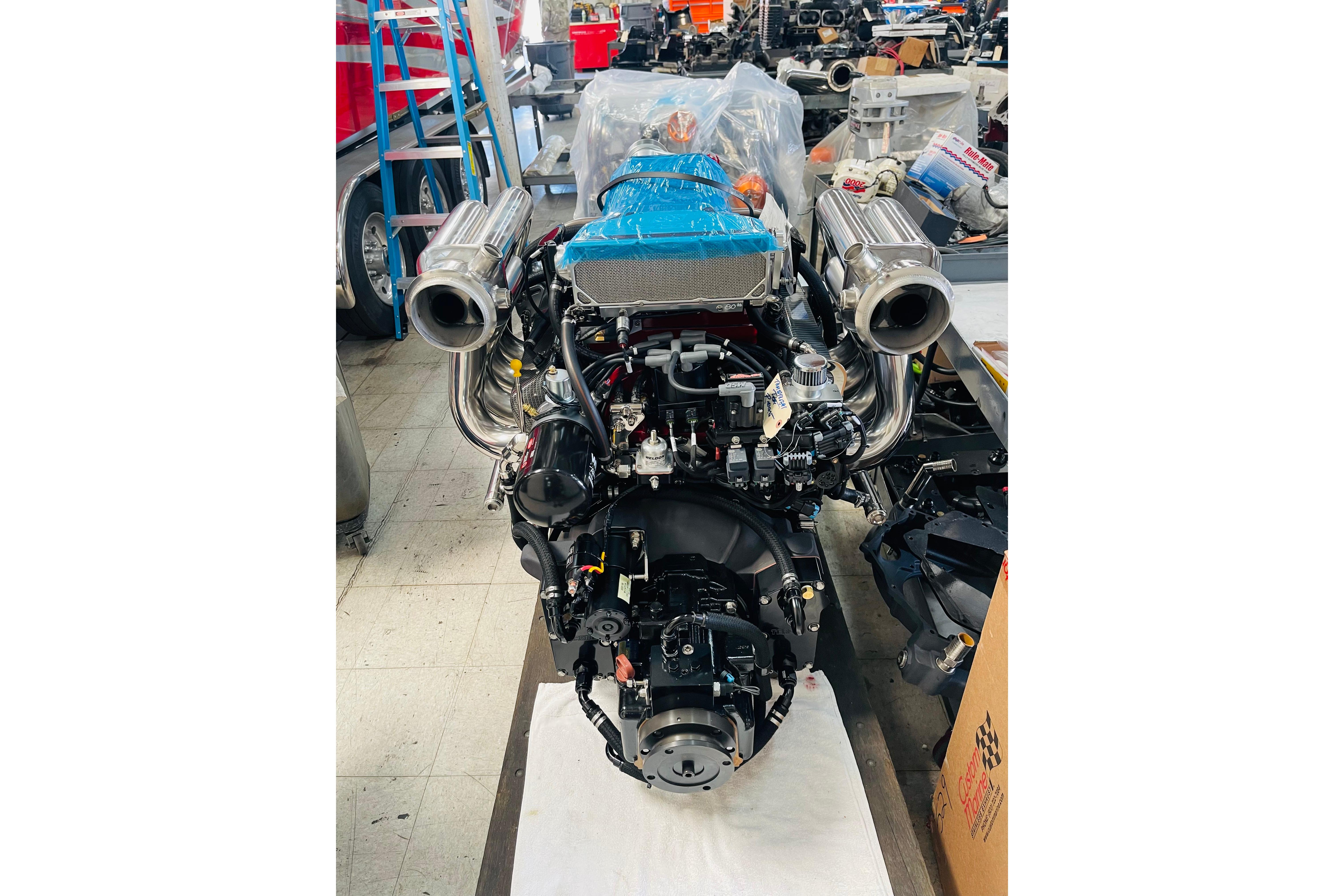 2013 Nordic 39 Poker Run engine in workshop, featuring dual exhausts and blue components.