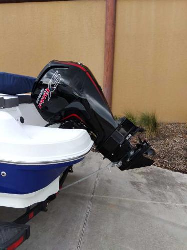 2024 Tahoe 185 S boat with powerful outboard motor in a driveway.