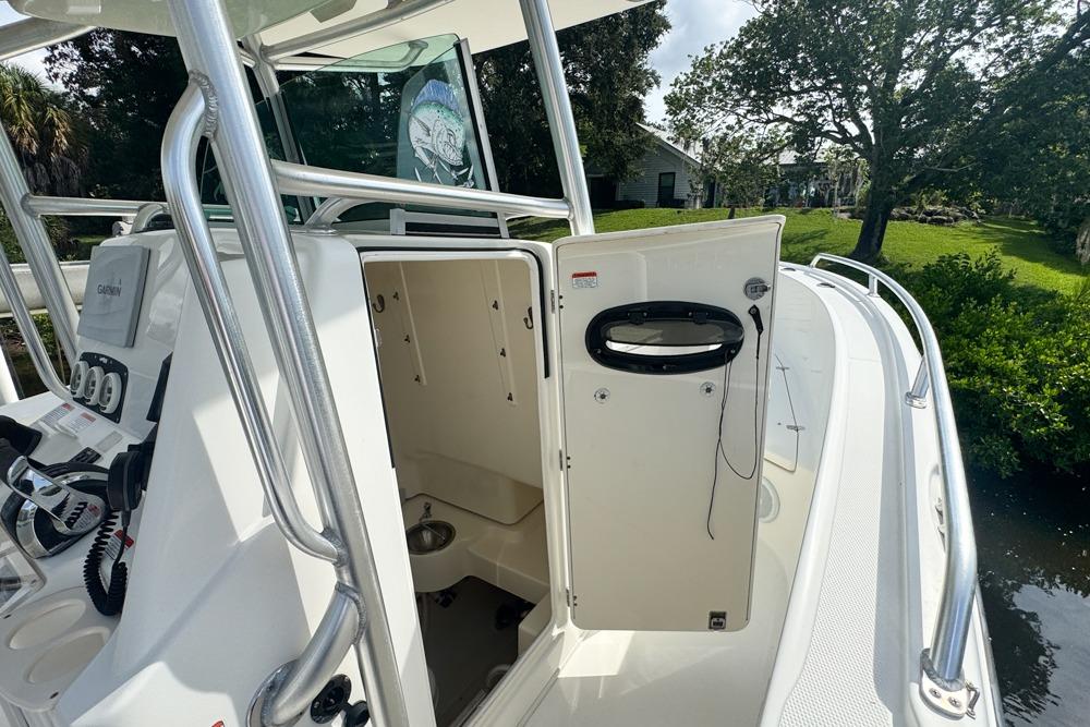 2018 Mako 284 Center Console boat with open cabin door, showcasing interior features.
