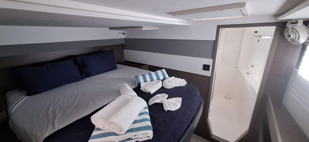 Luxurious cabin interior of 2024 Leopard 50 yacht with cozy bed and modern bathroom.