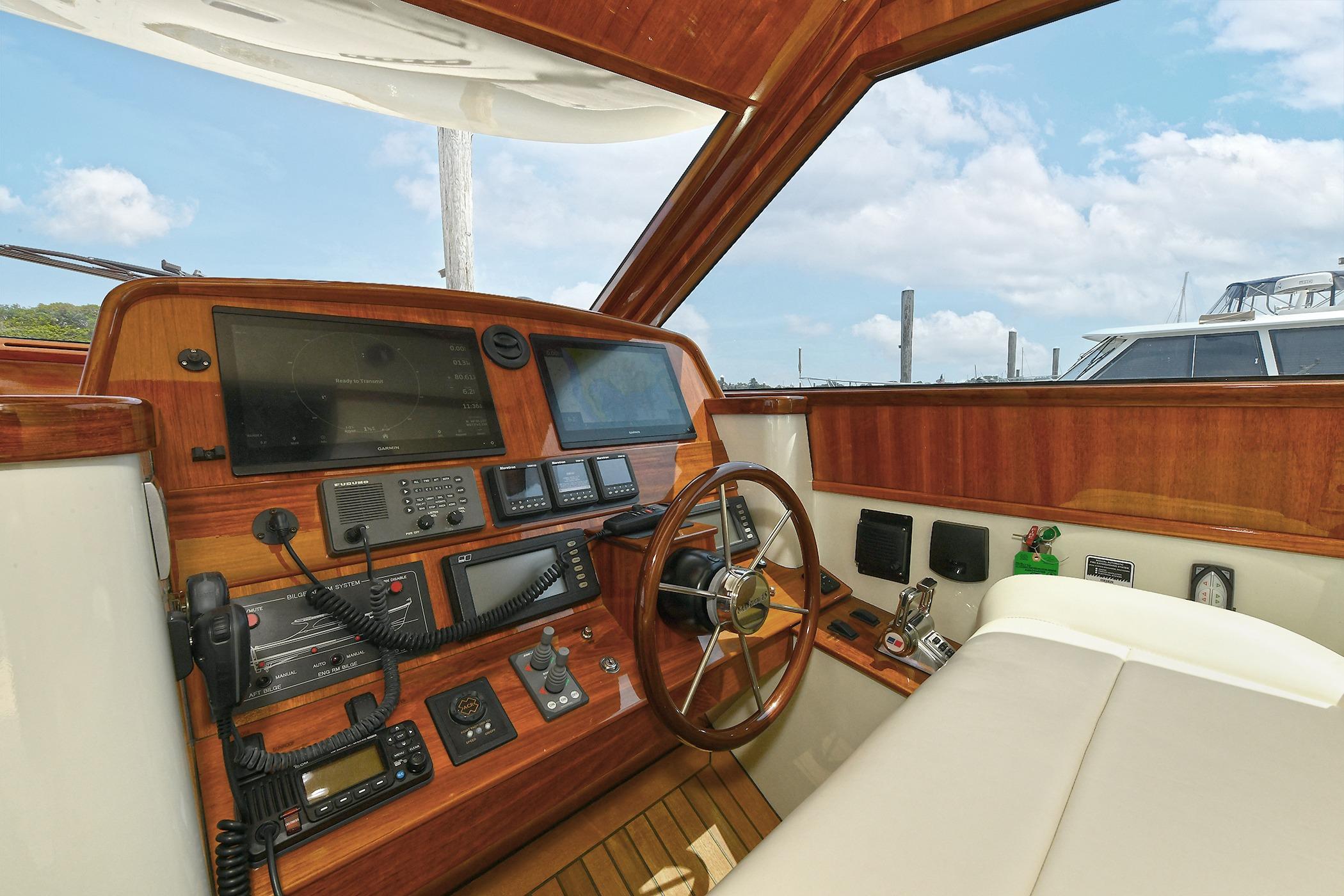 Helm of 2005 San Juan Downeast Express yacht with wooden dashboard and navigation equipment.