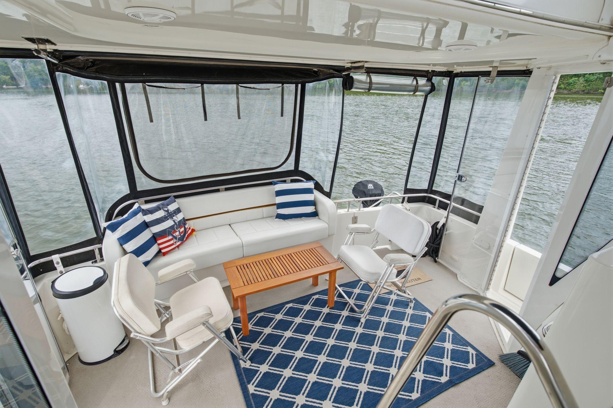 Luxurious 2005 Carver 39 Motor Yacht interior with seating, table, and lake view.