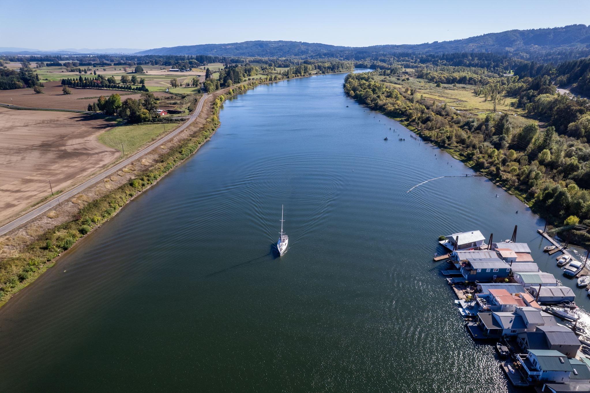 Aerial view of 2013 Beneteau Oceanis 50 sailing on a scenic river.