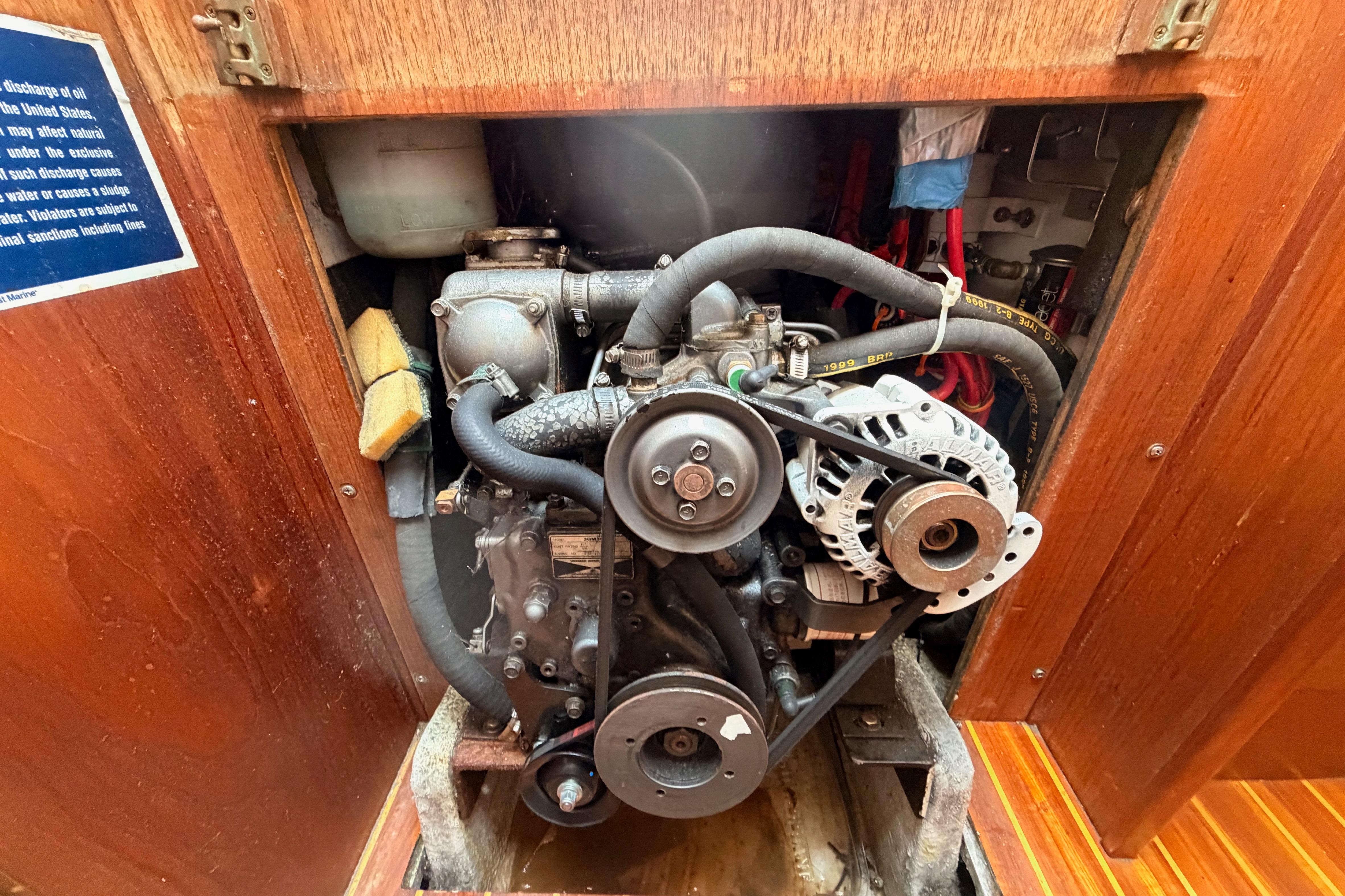 Engine compartment of a 1991 Caliber 33 sailboat, showcasing mechanical components and wiring.