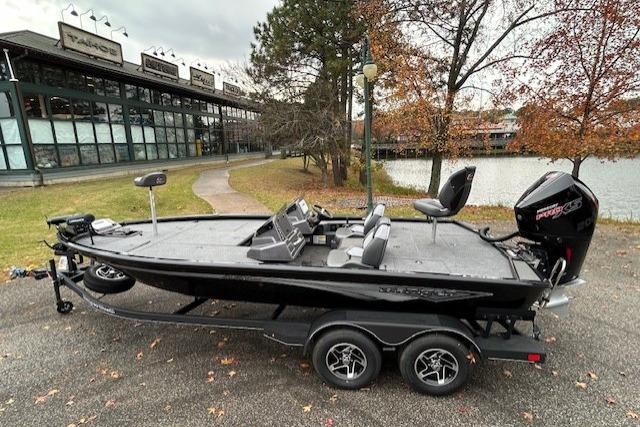 2025 Ranger ALPHA 208 fishing boat on trailer near a lake and trees.