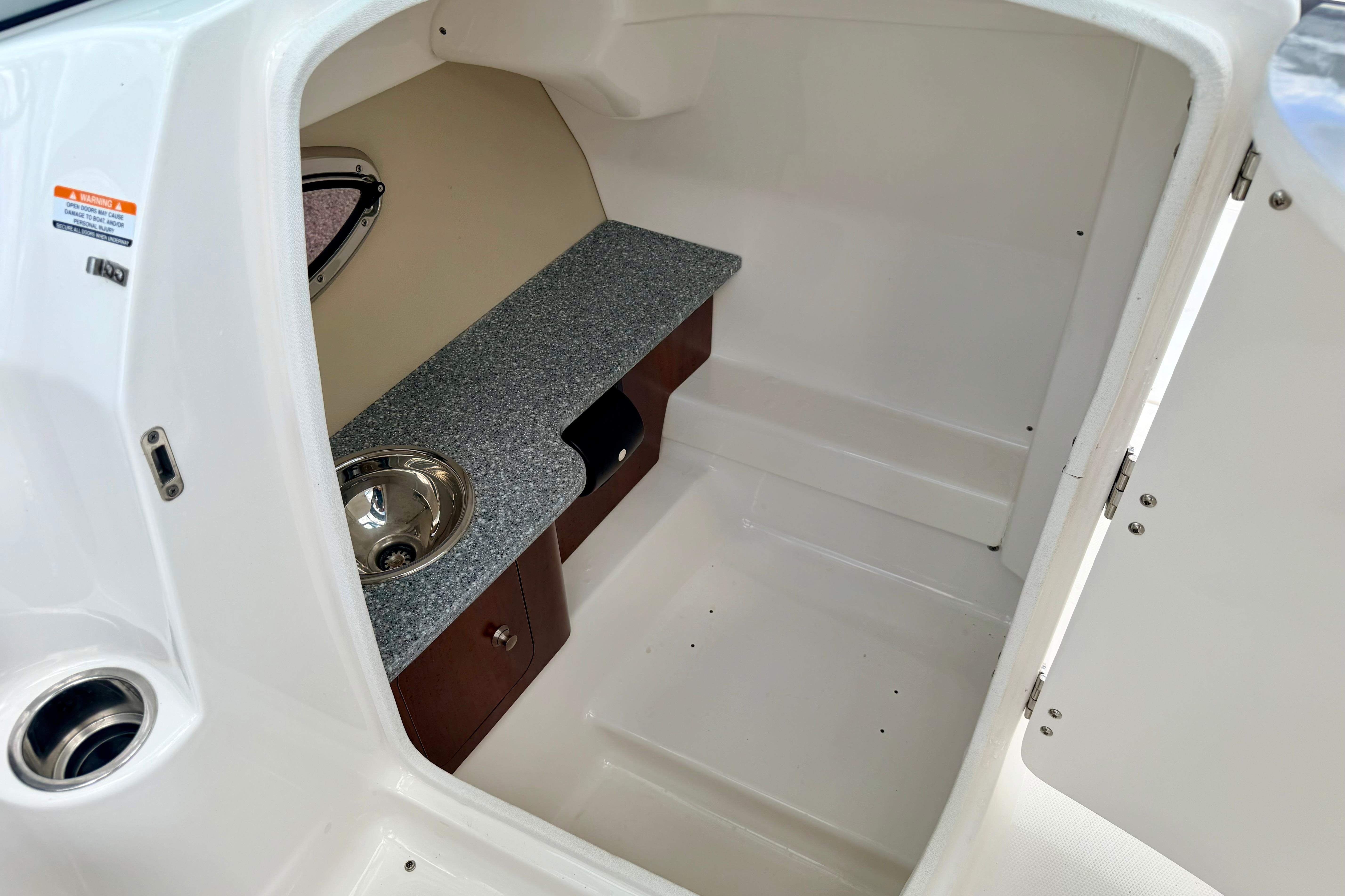 2015 Chaparral Sunesta 264 boat interior with sink and storage area.