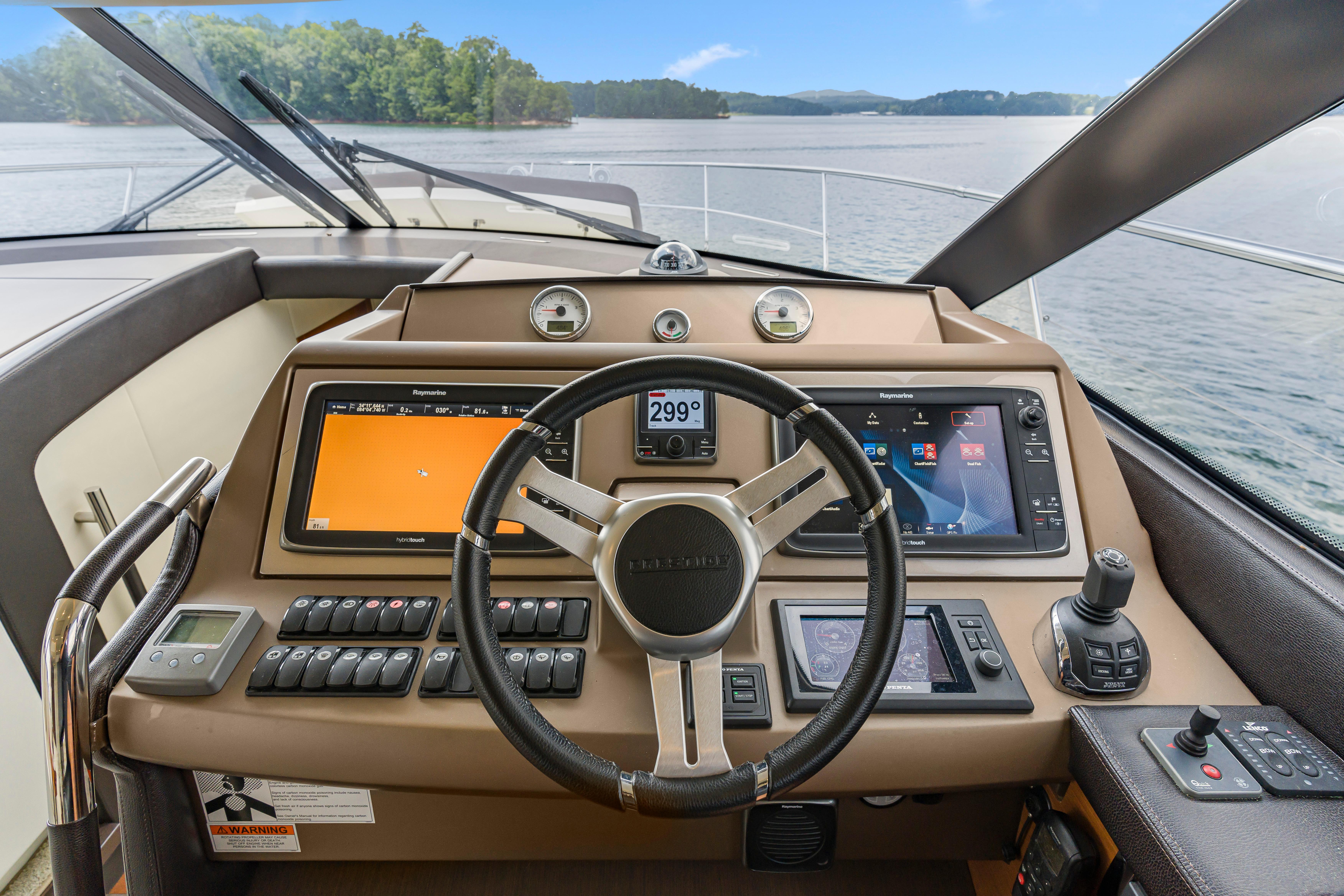 Cockpit of 2017 Prestige 500 yacht with advanced navigation controls and scenic water view.
