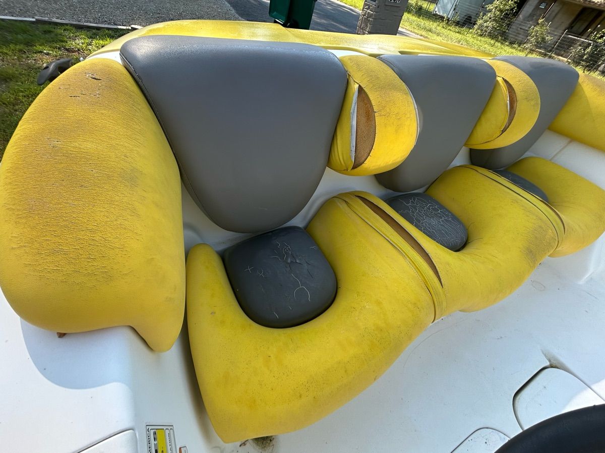 Yellow and gray seats in a boat, slightly worn, on a white background.