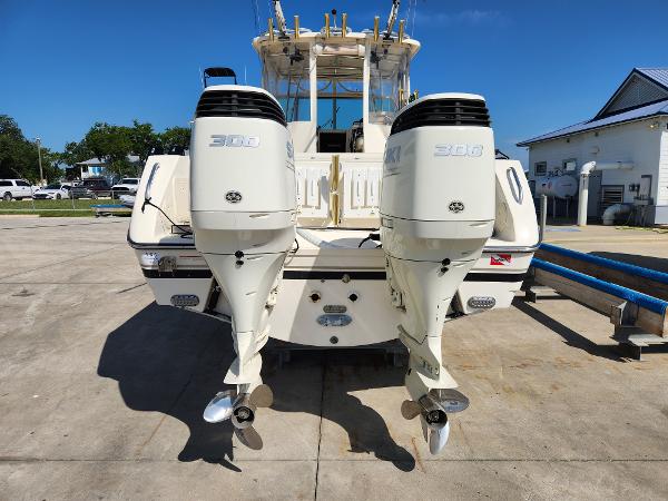 2005 Pursuit 3070 Offshore Center Console with twin outboard engines, parked on concrete.