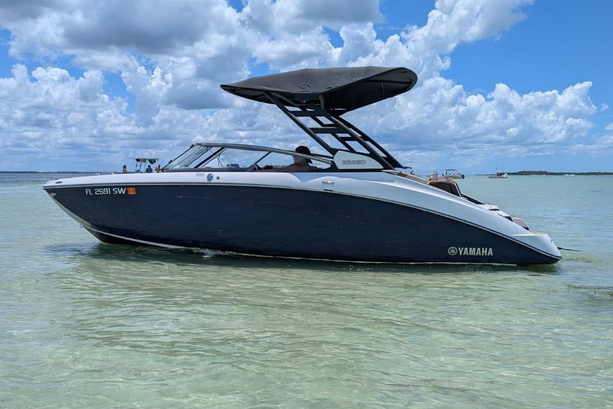 A 2021 Yamaha 252SD boat on calm water under a blue sky.