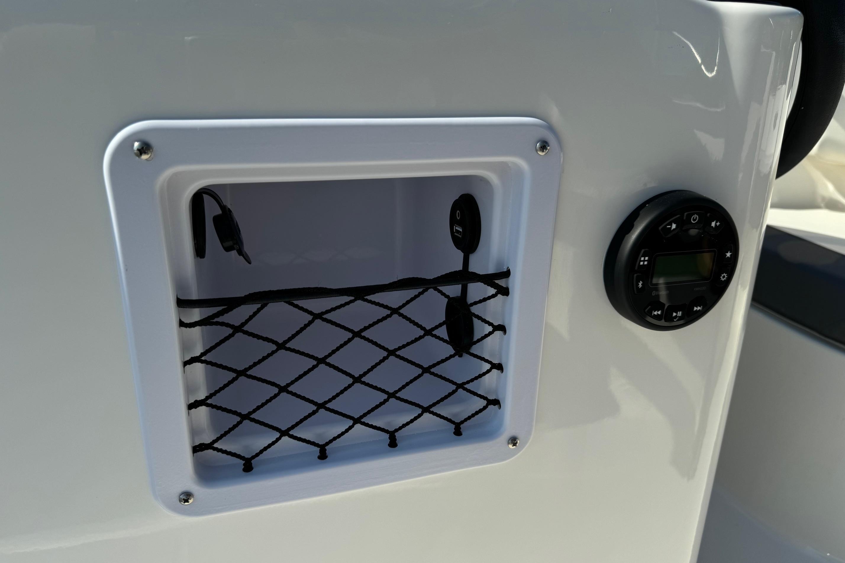 2025 Bayliner Element E16 boat dashboard with storage compartment and control panel.