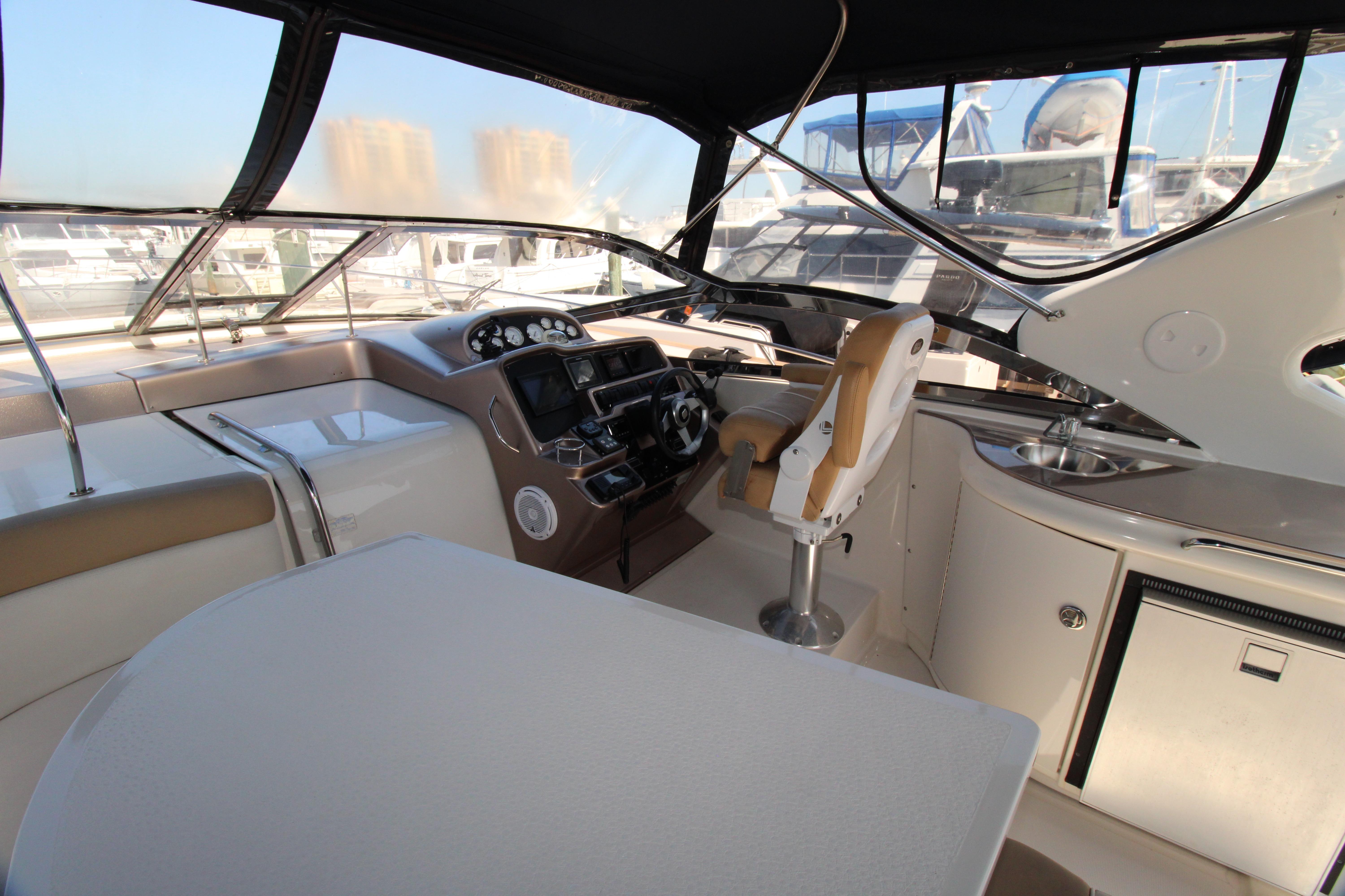 2002 Regal Commodore 4260 yacht cockpit with helm, seating, and panoramic windows.