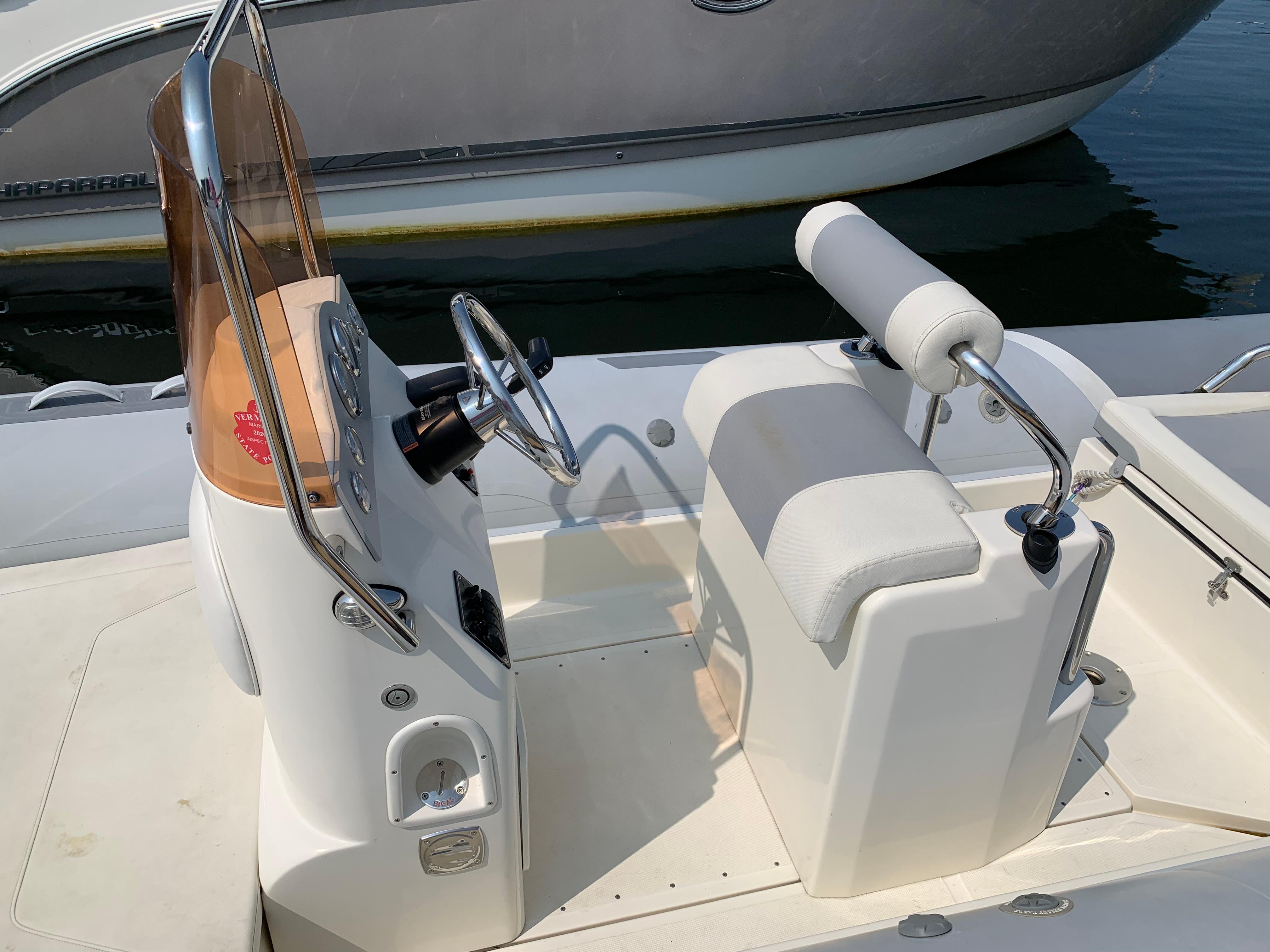 2019 Inmar 635 boat interior with steering console and cushioned seating.