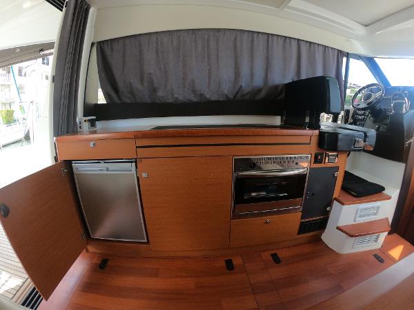Interior of 2017 Jeanneau NC 11 yacht with kitchen and helm station.