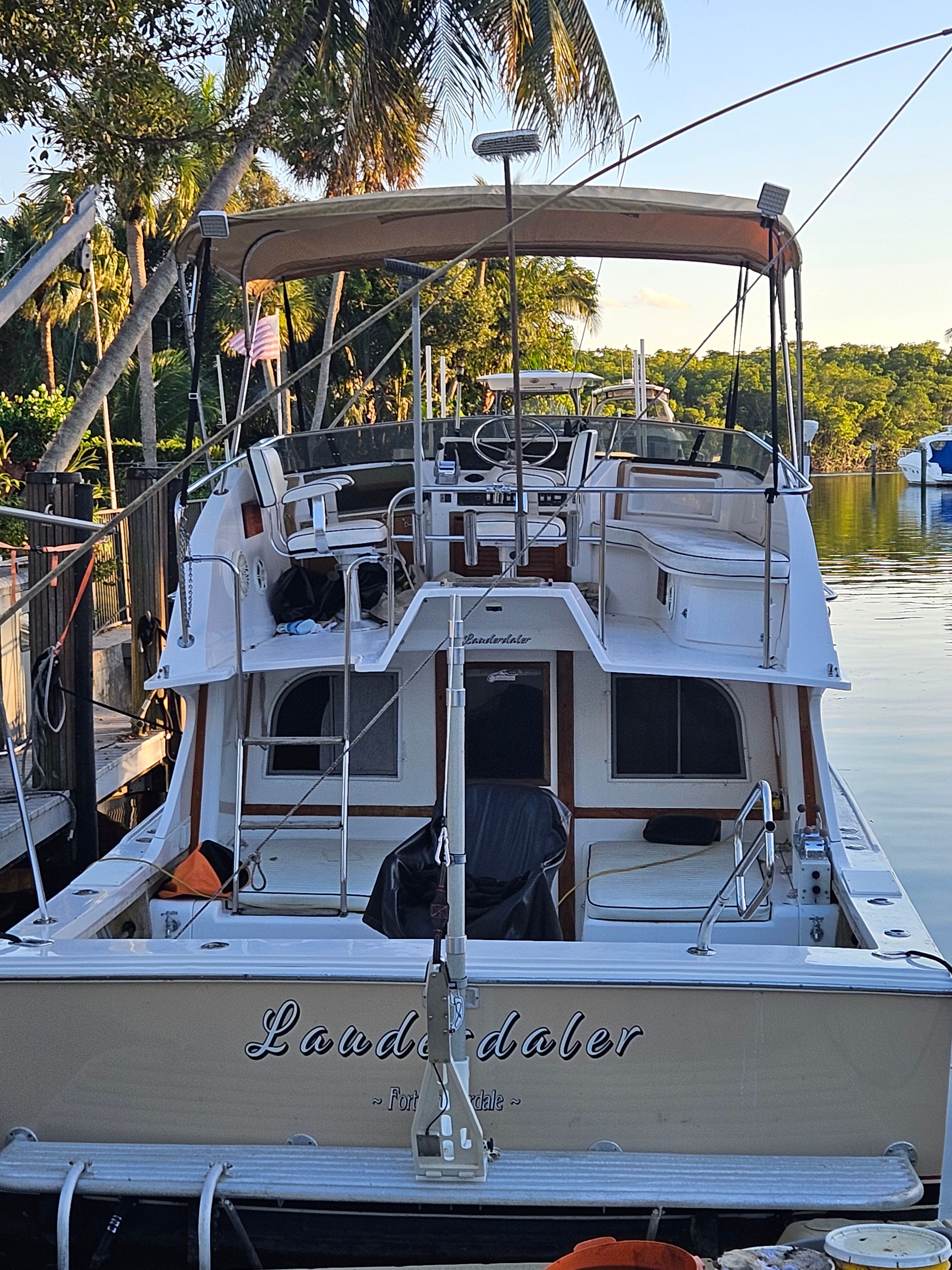 Rear view of a 1990 Blackfin 29SF boat at a calm dock.