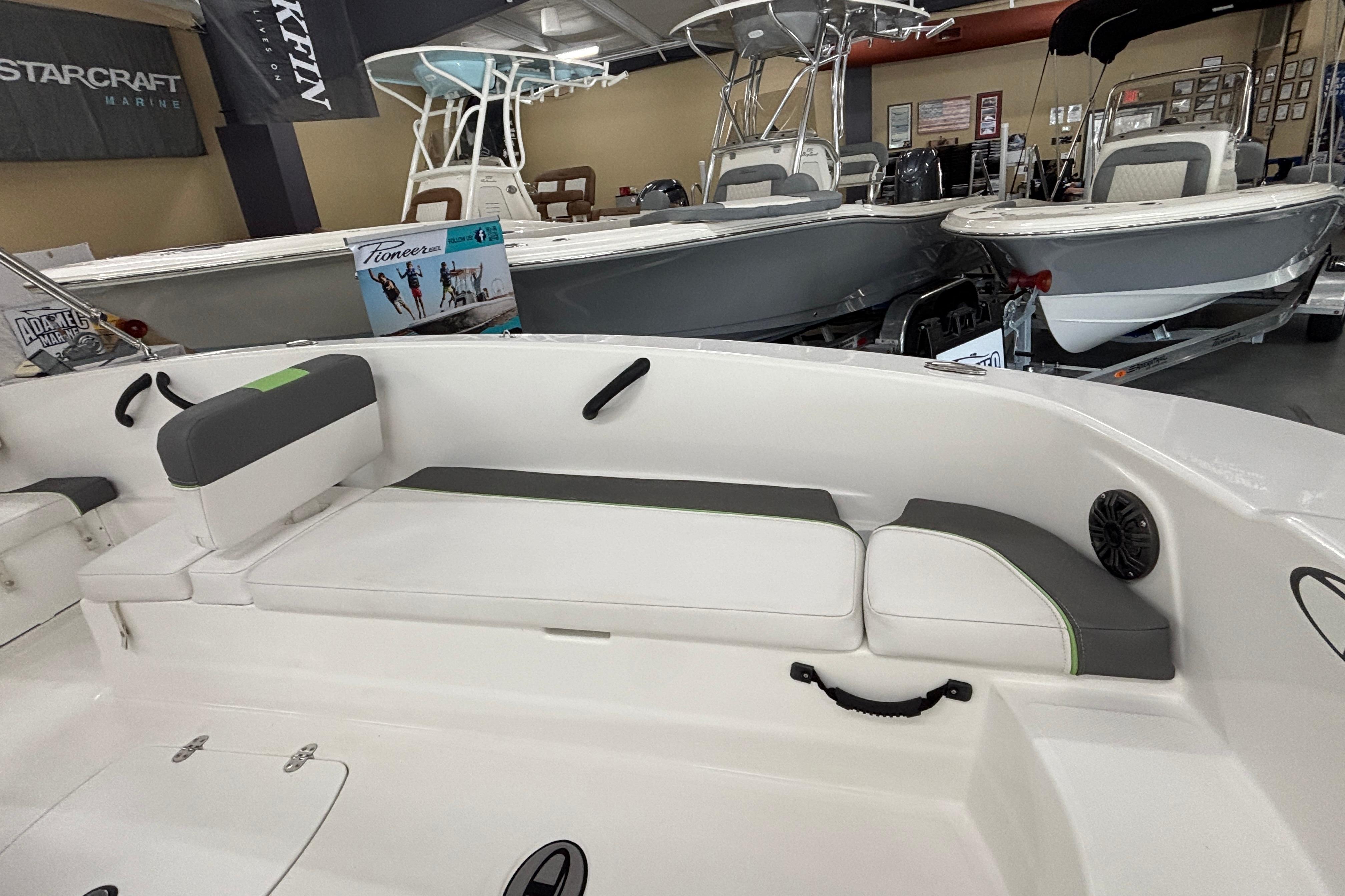 2024 Tahoe T18 boat interior with cushioned seating in a showroom.