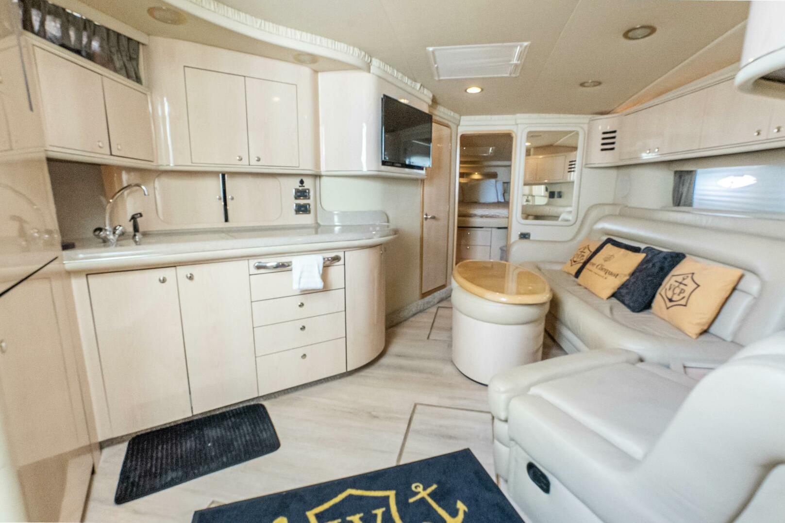 Luxurious interior of a 2003 Sea Ray Sundancer 460 yacht with modern kitchen and seating area.