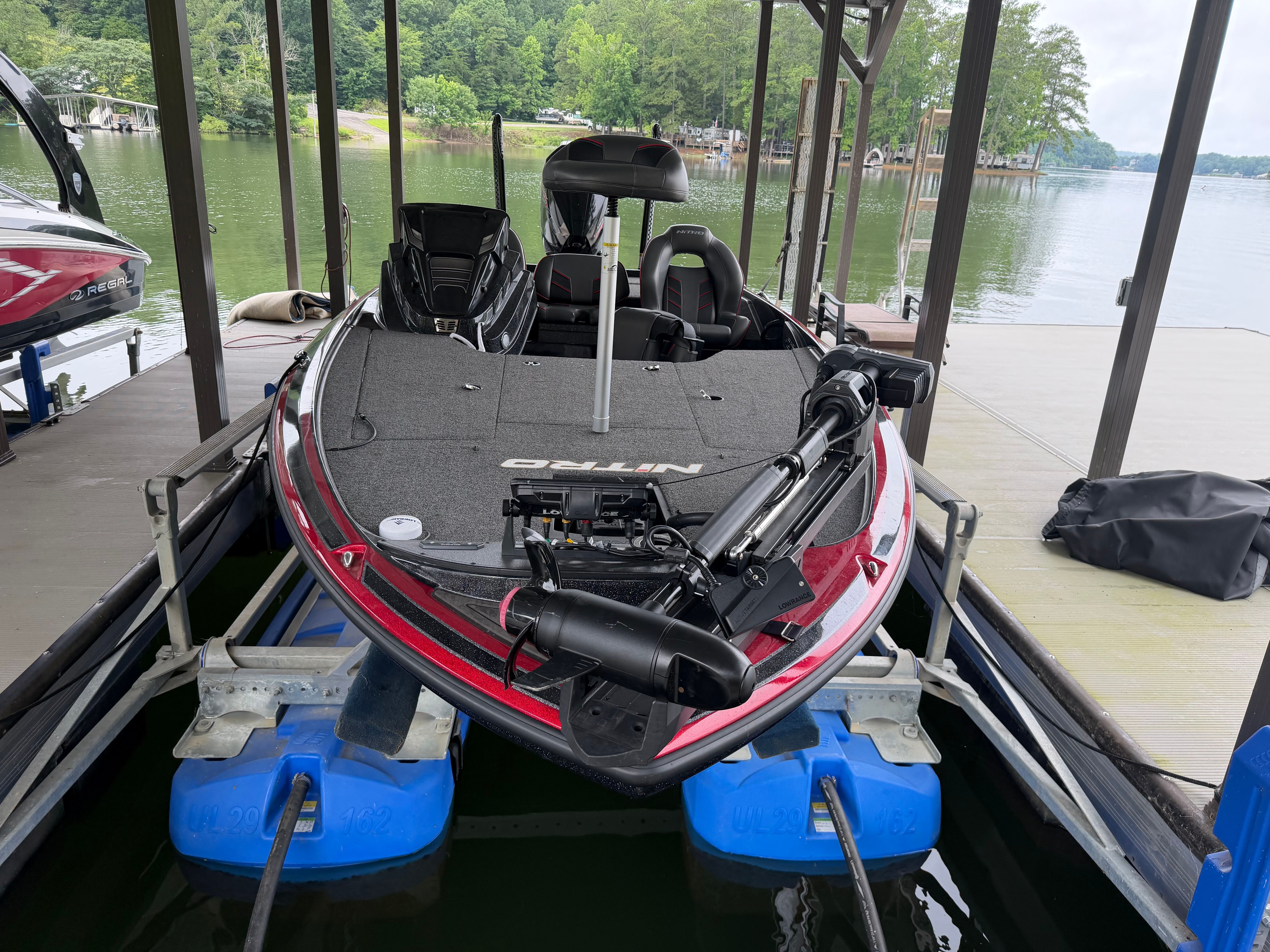 A 2024 Tracker Z19 boat is docked in a covered slip on a lake.