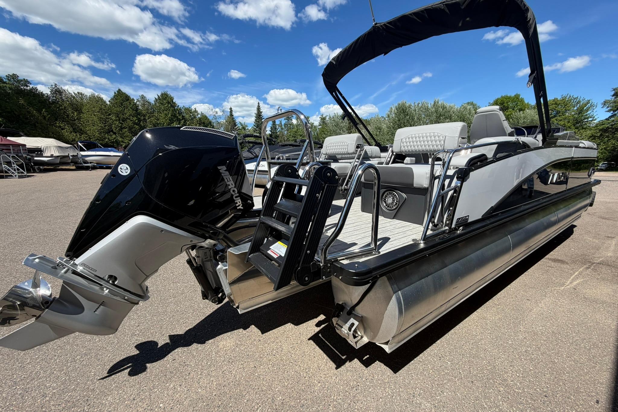 2026 Avalon Catalina Quad Lounge Shift pontoon boat with Mercury engine, parked outdoors.