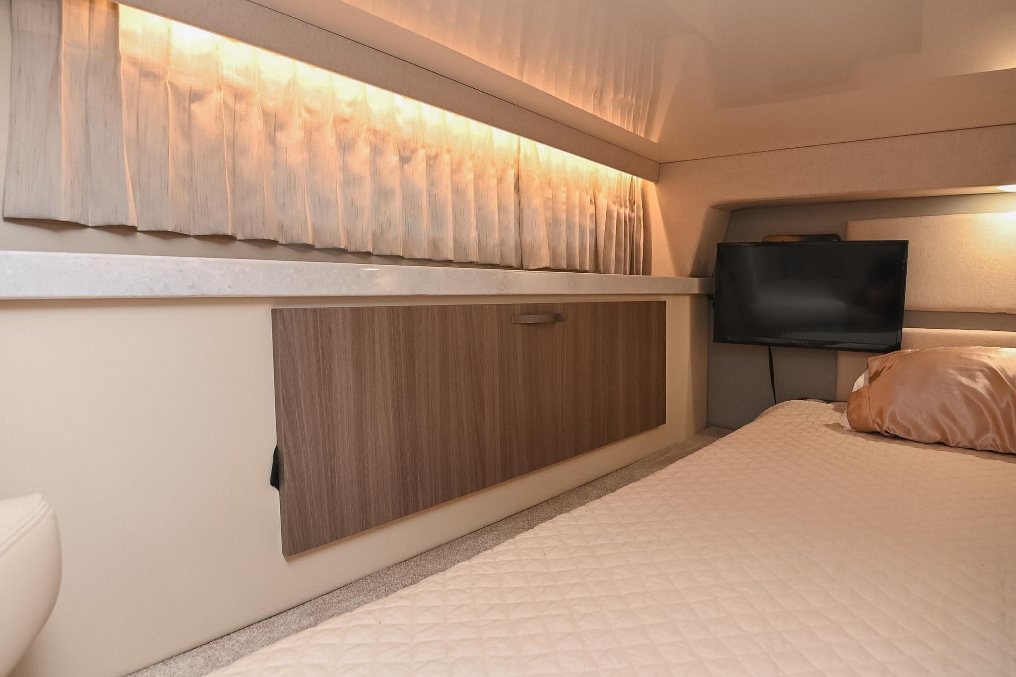 2021 Regal 33 Express cabin interior with bed, TV, and ambient lighting.