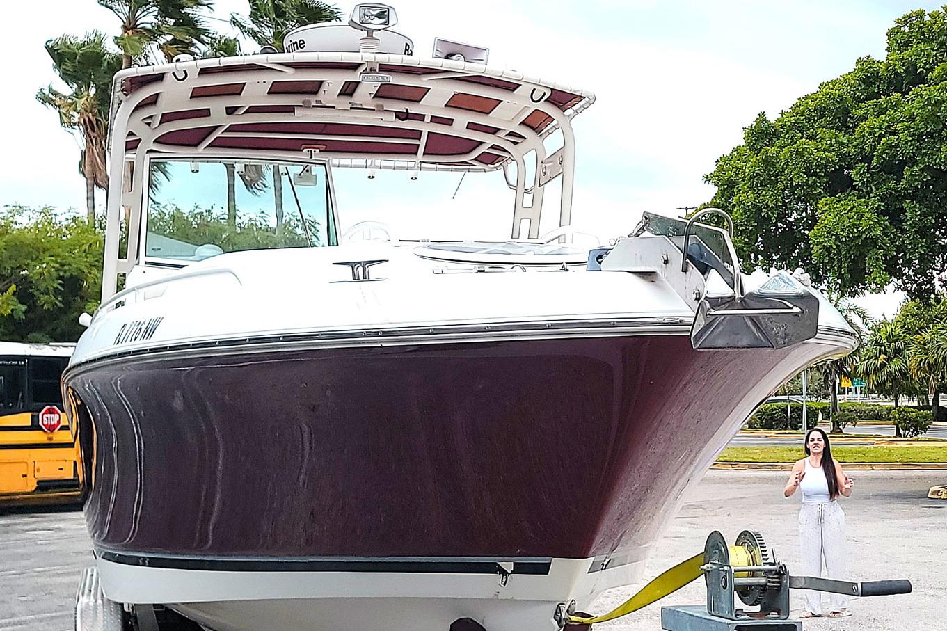 2008 Wellcraft 30 Scarab Sport boat on trailer, parked outdoors with trees in background.