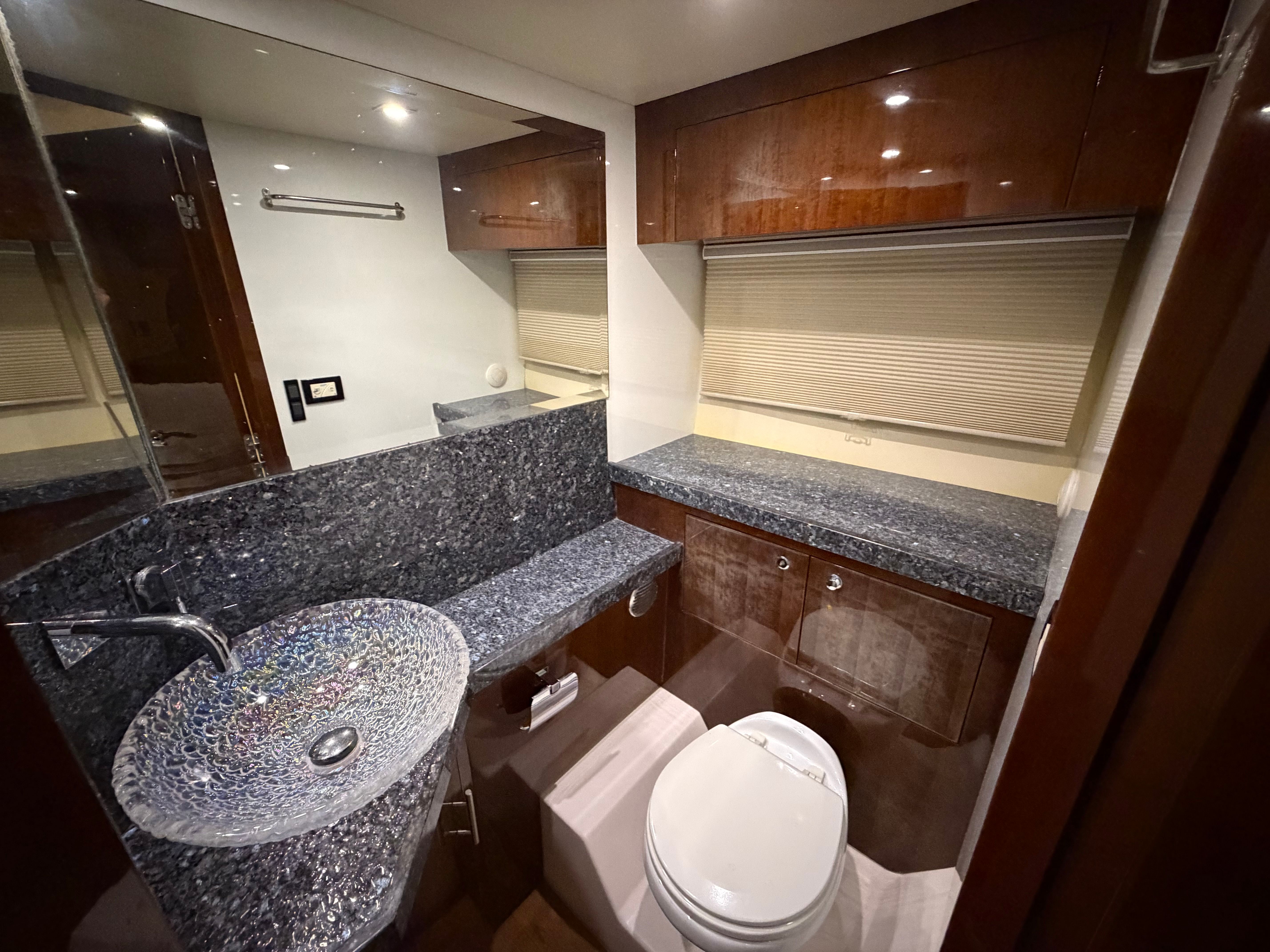 Luxurious bathroom in 2014 Regal 52 Sport Coupe yacht with elegant granite countertops.