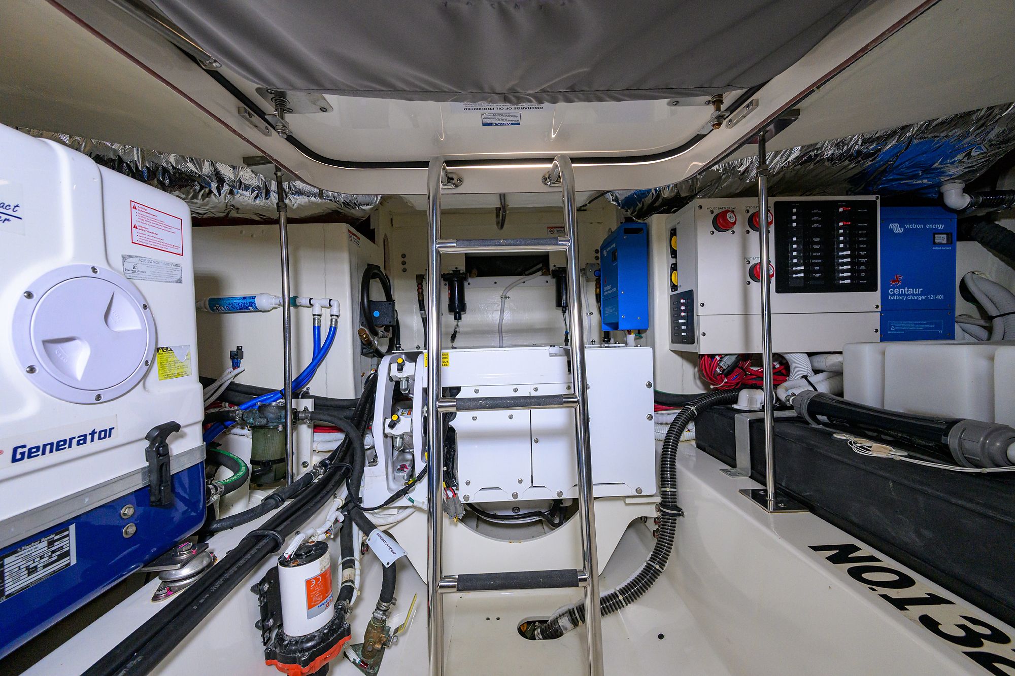 The engine room of a 2022 Tiara Yachts 43 LE, featuring technical equipment and wiring.
