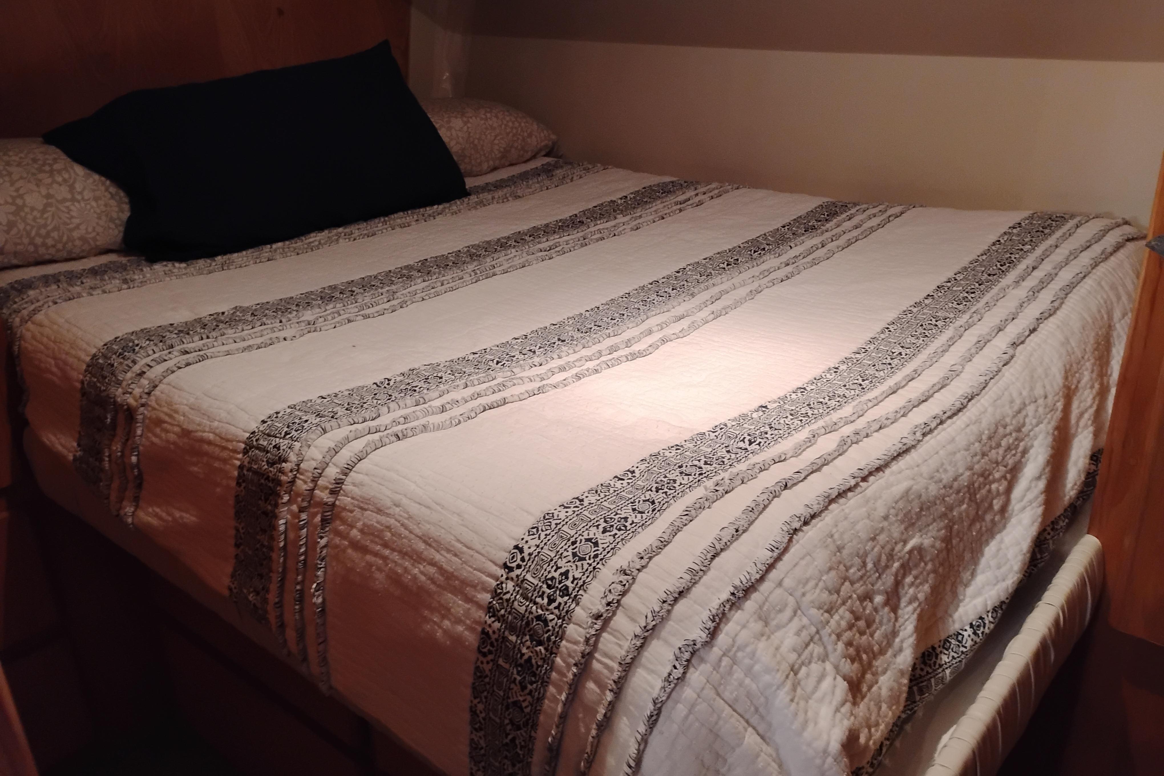Cozy bed with patterned quilt in 1994 Navigator Classic interior.