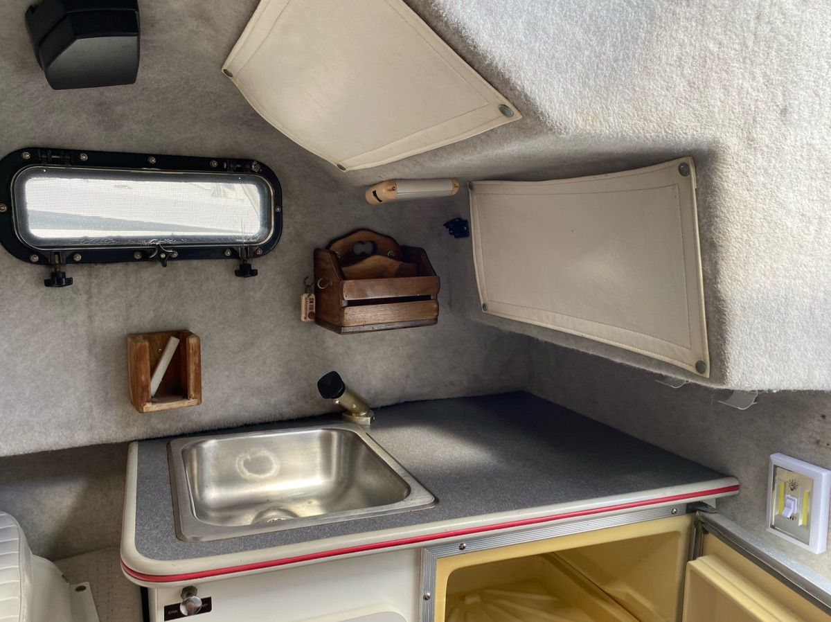 Interior of 1990 Bayliner 2302 Trophy with sink and storage.
