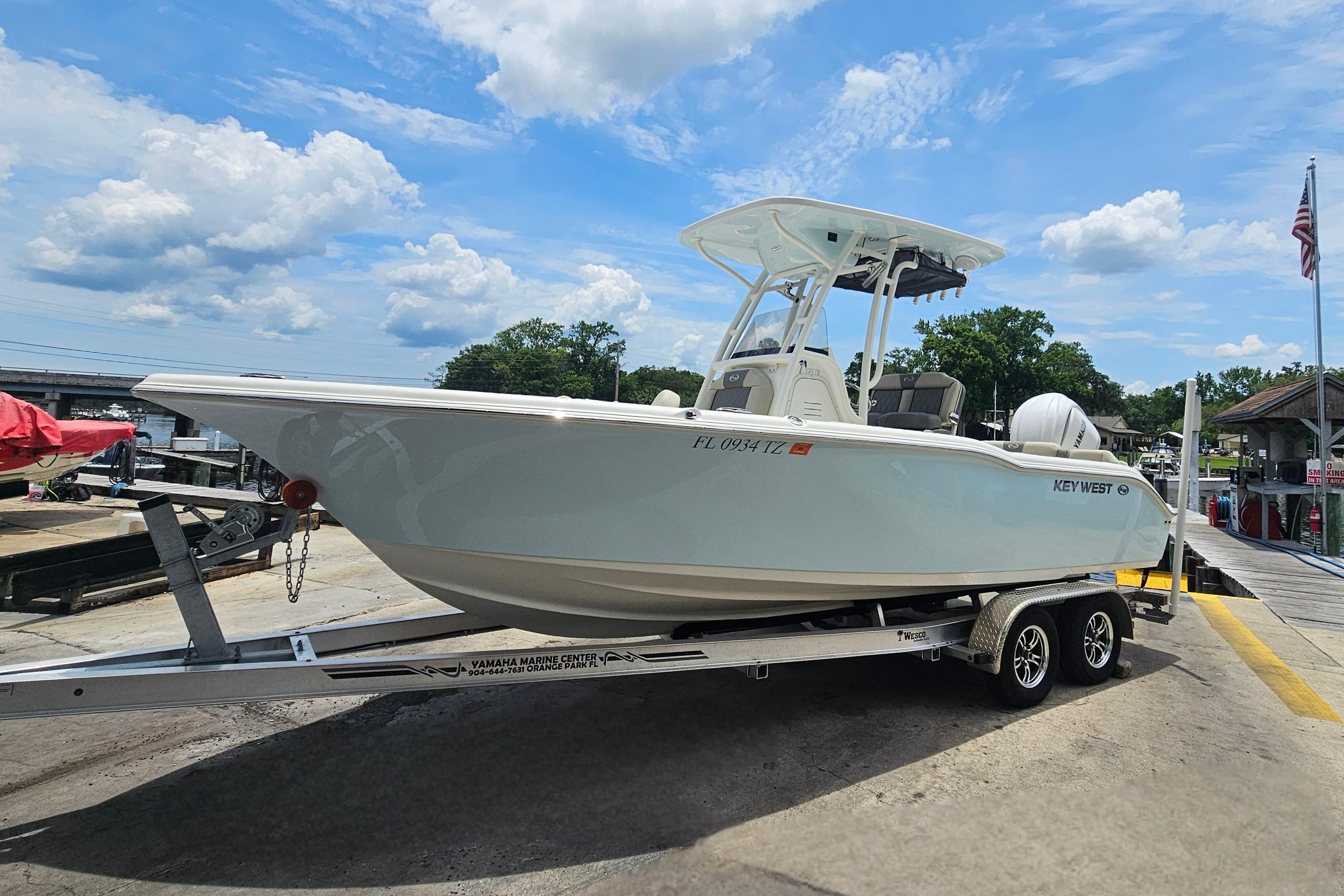 2025 Key West 239 FS boat on trailer at marina under blue sky.